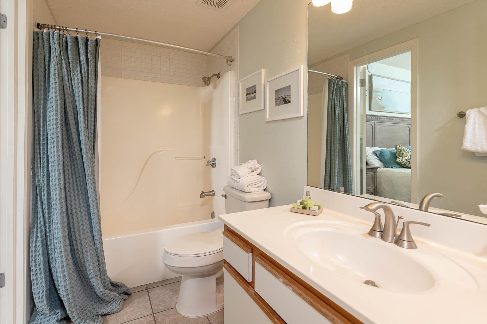 Image 3: Full bath with visible vents, toilet, shower / bath combo, tile patterned floors, and vanity