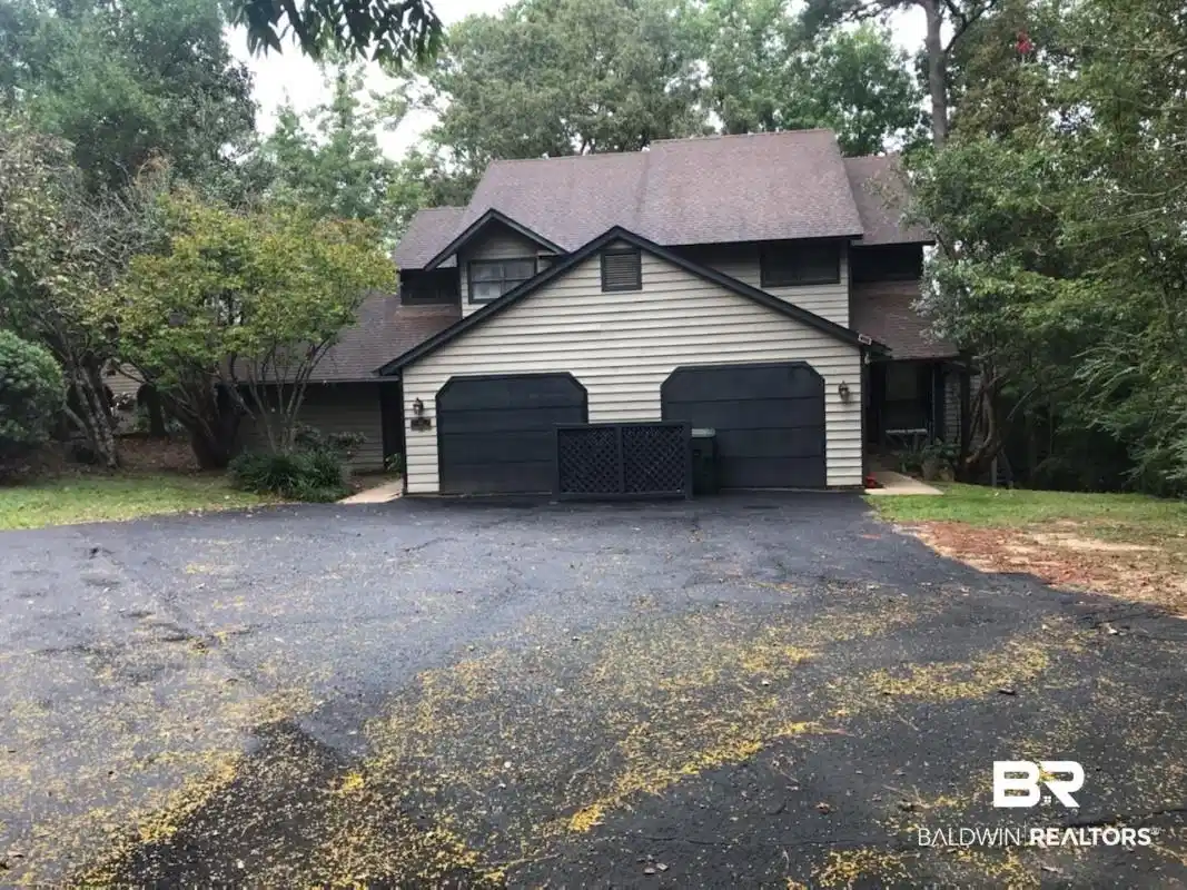 Image 1: View of home's exterior with asphalt driveway, a garage, a shingled roof, and view of wooded area