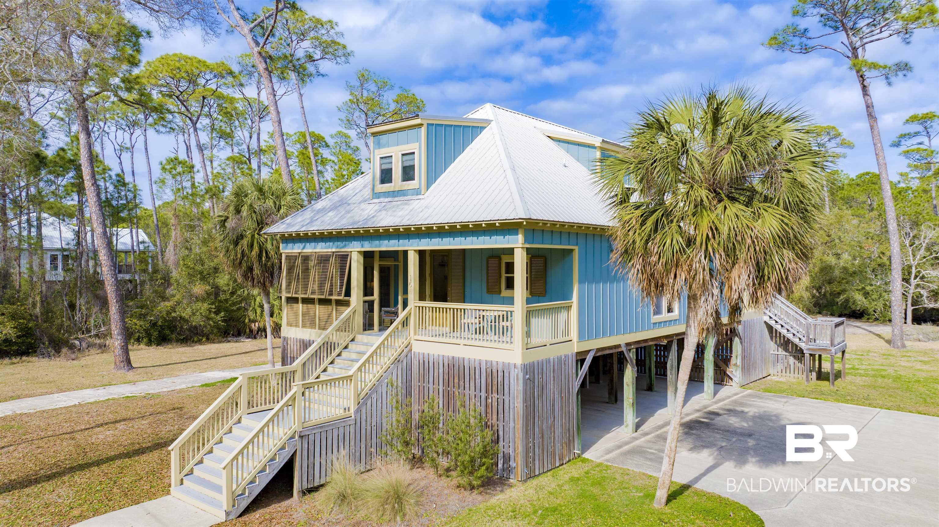 Image 2: View of front of house featuring a carport, a metal roof, and a front lawn