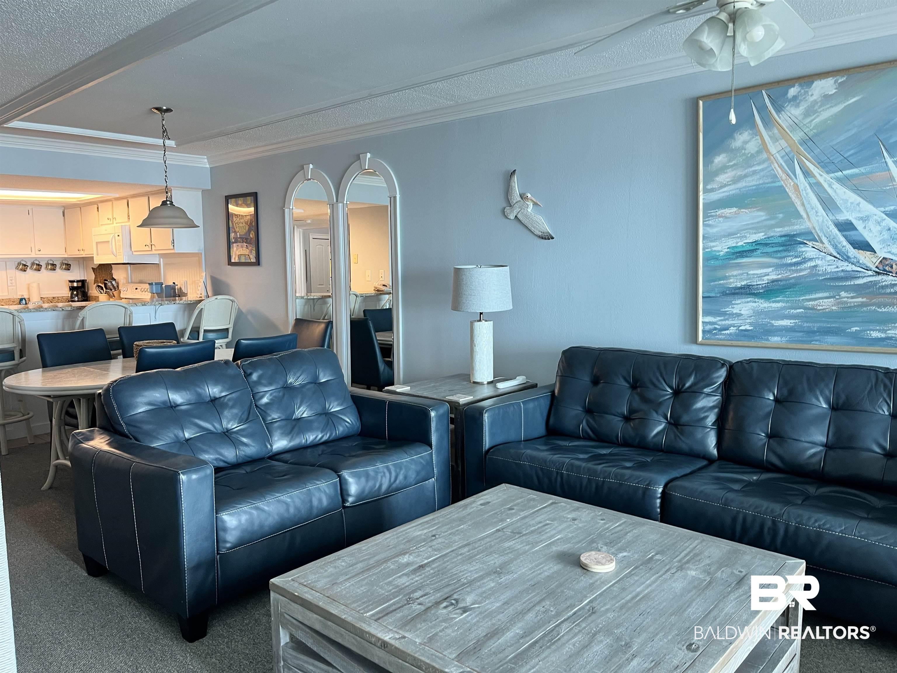 Image 3: Living room with dark colored carpet, crown molding, ceiling fan, and a textured ceiling