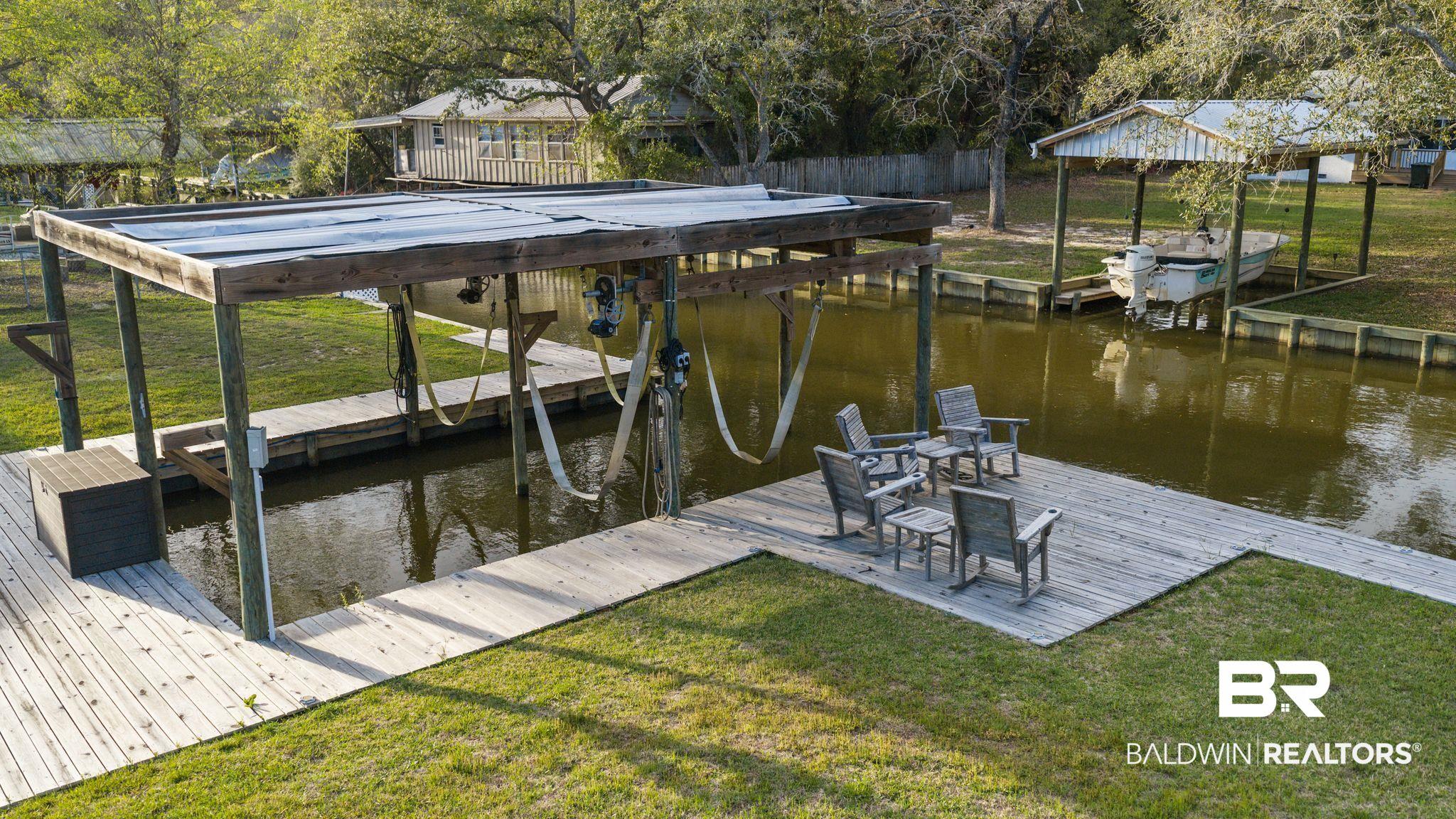Image 2: Dock area with a lawn, a water view, and boat lift