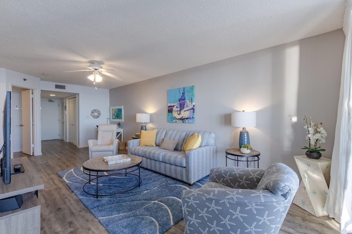 Image 4: Living room with wood finished floors, a textured ceiling, and ceiling fan