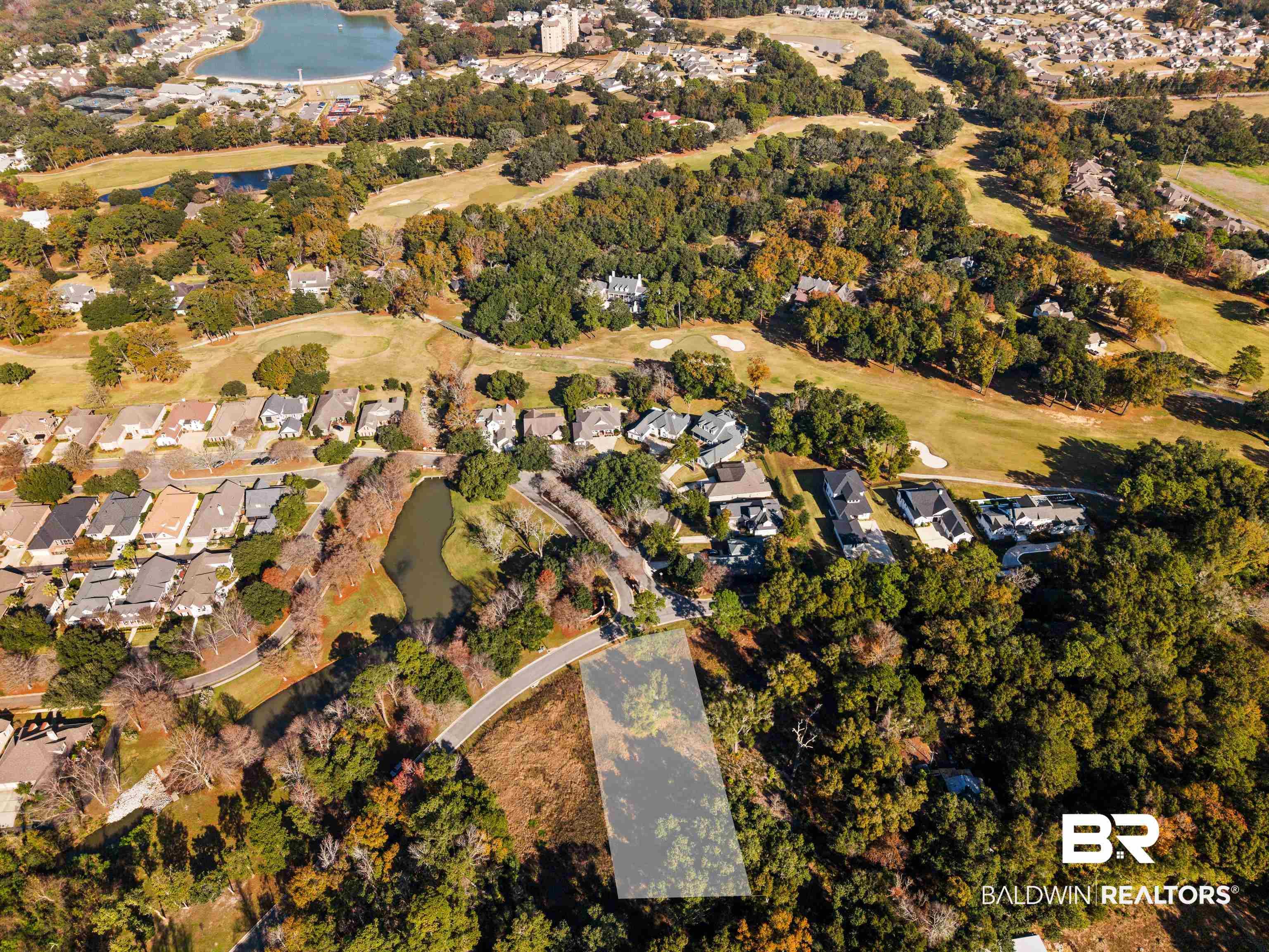 Image 3: Aerial overview of property's location with a large body of water, nearby suburban area, and a golf course