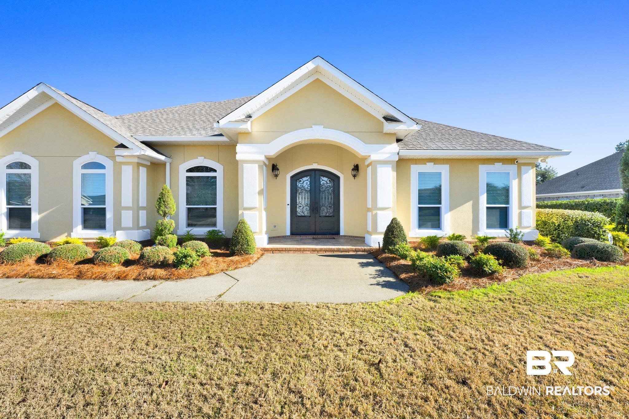 Image 4: View of front of home featuring french doors, a shingled roof, stucco siding, and a front lawn