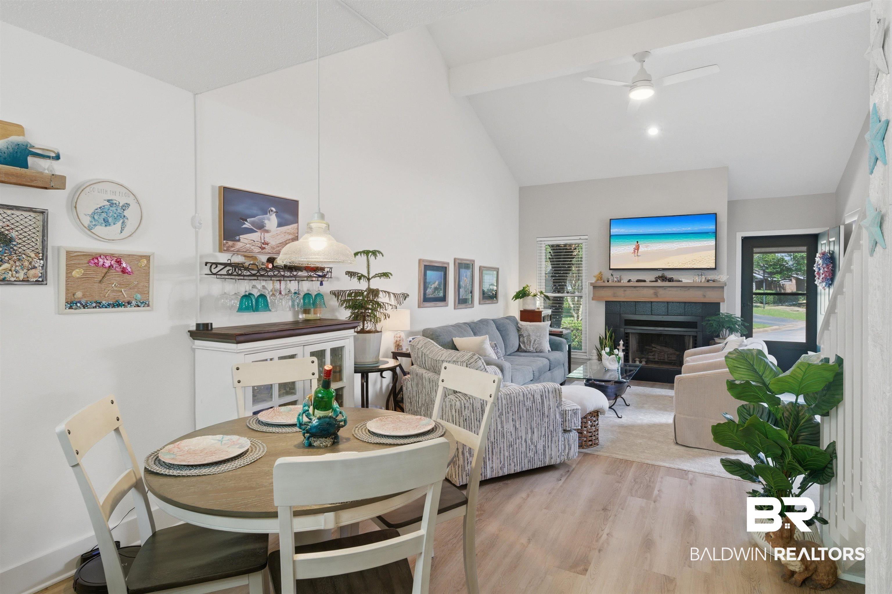 Image 3: Bright and open with LVP floors, vaulted ceilings and a fireplace.