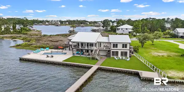 Image 2: Waterfront residence featuring a private dock, expansive deck, and a sparkling pool
