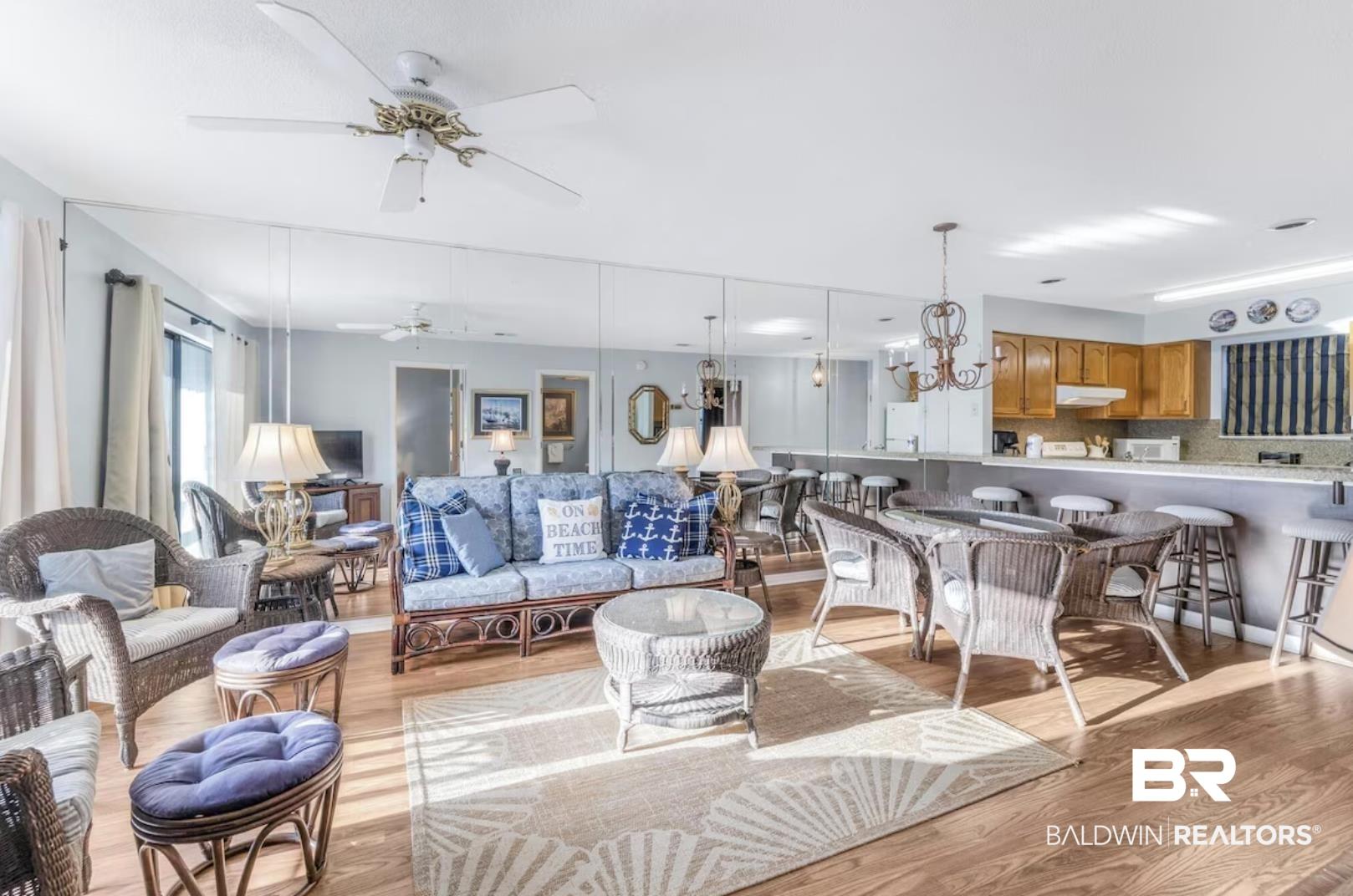 Image 4: Living area with a chandelier, light wood-style floors, and ceiling fan