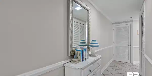 Image 2: Hallway featuring light gray walls with chair rail molding, square tile flooring laid in a diagonal pattern, and recessed ceiling lighting