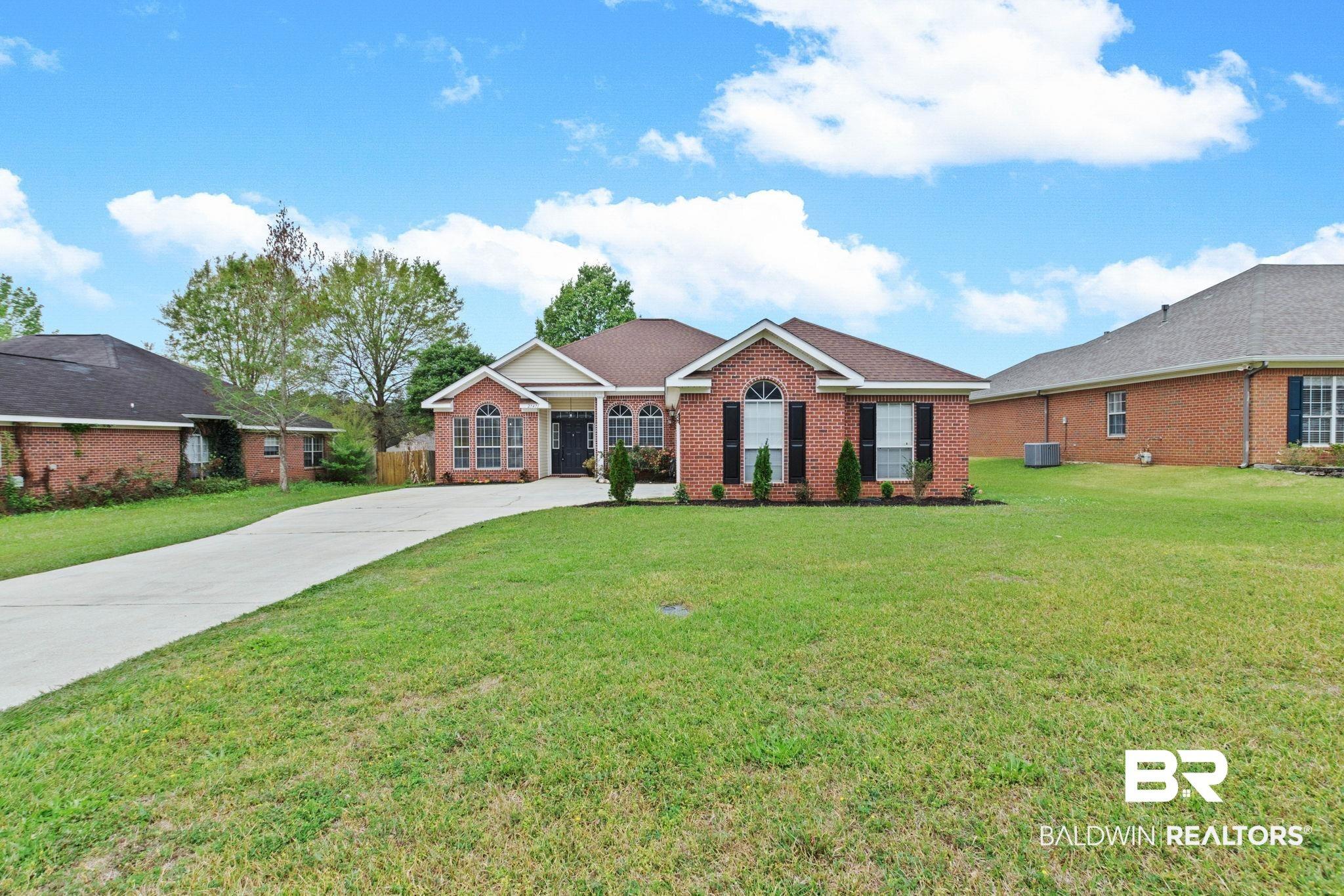 Image 2: Single story home with brick siding, a front yard, and driveway