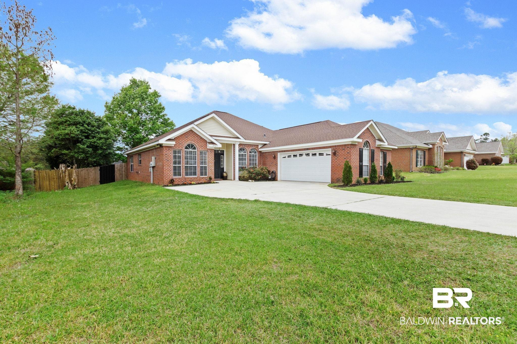 Image 3: Ranch-style home with brick siding, concrete driveway, and a garage