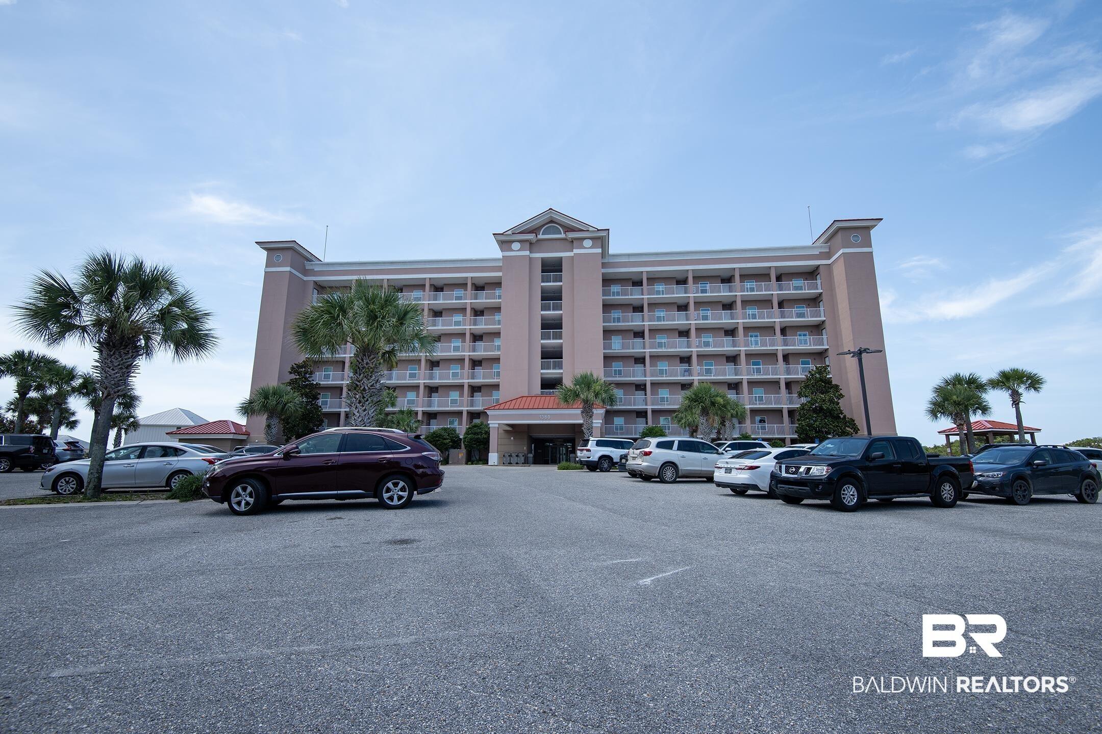 Image 3: Multi-story building featuring numerous balconies and a central entrance portico with a red tile roof