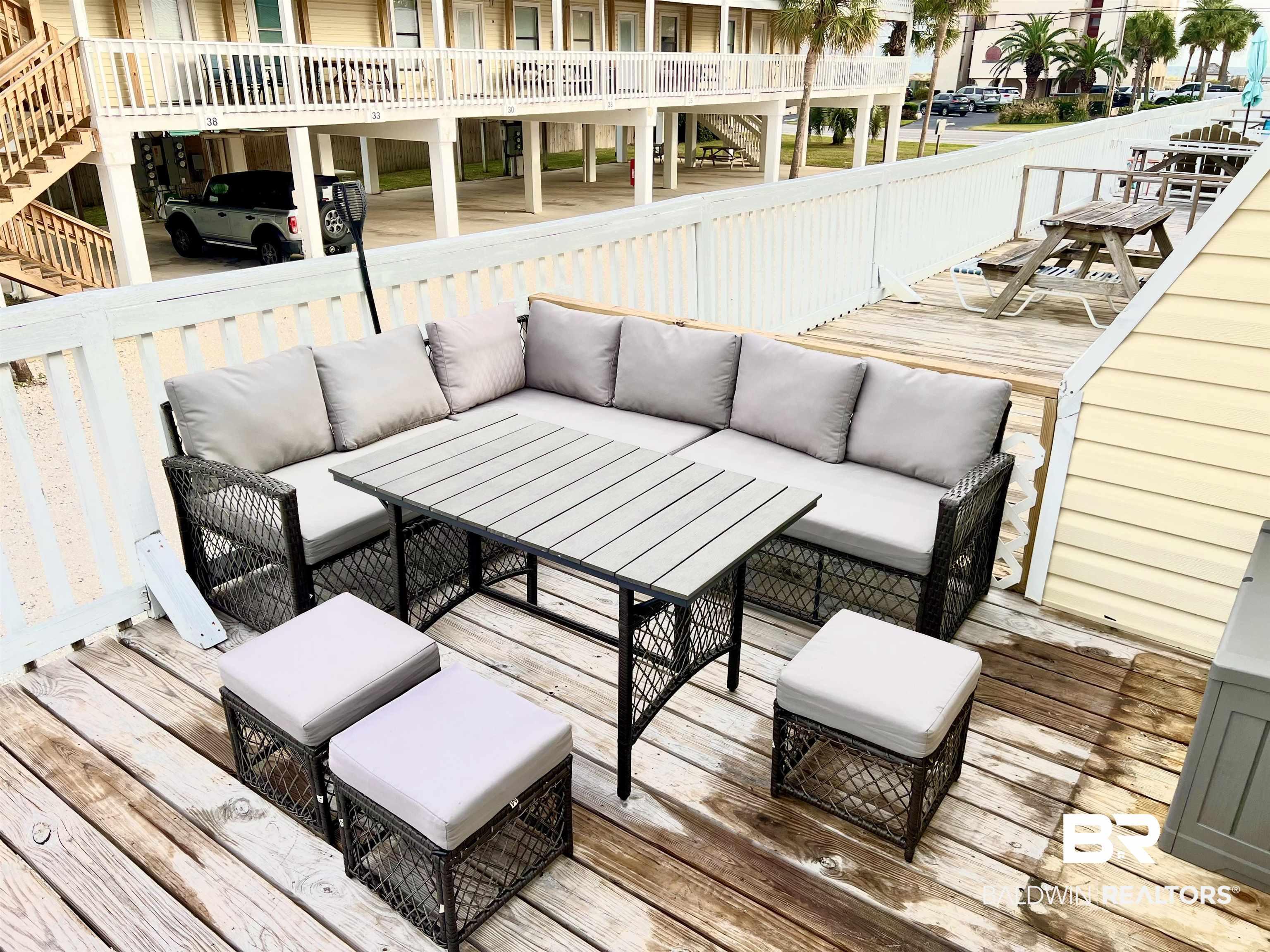 Image 2: Wooden deck with outdoor lounge area and stairway