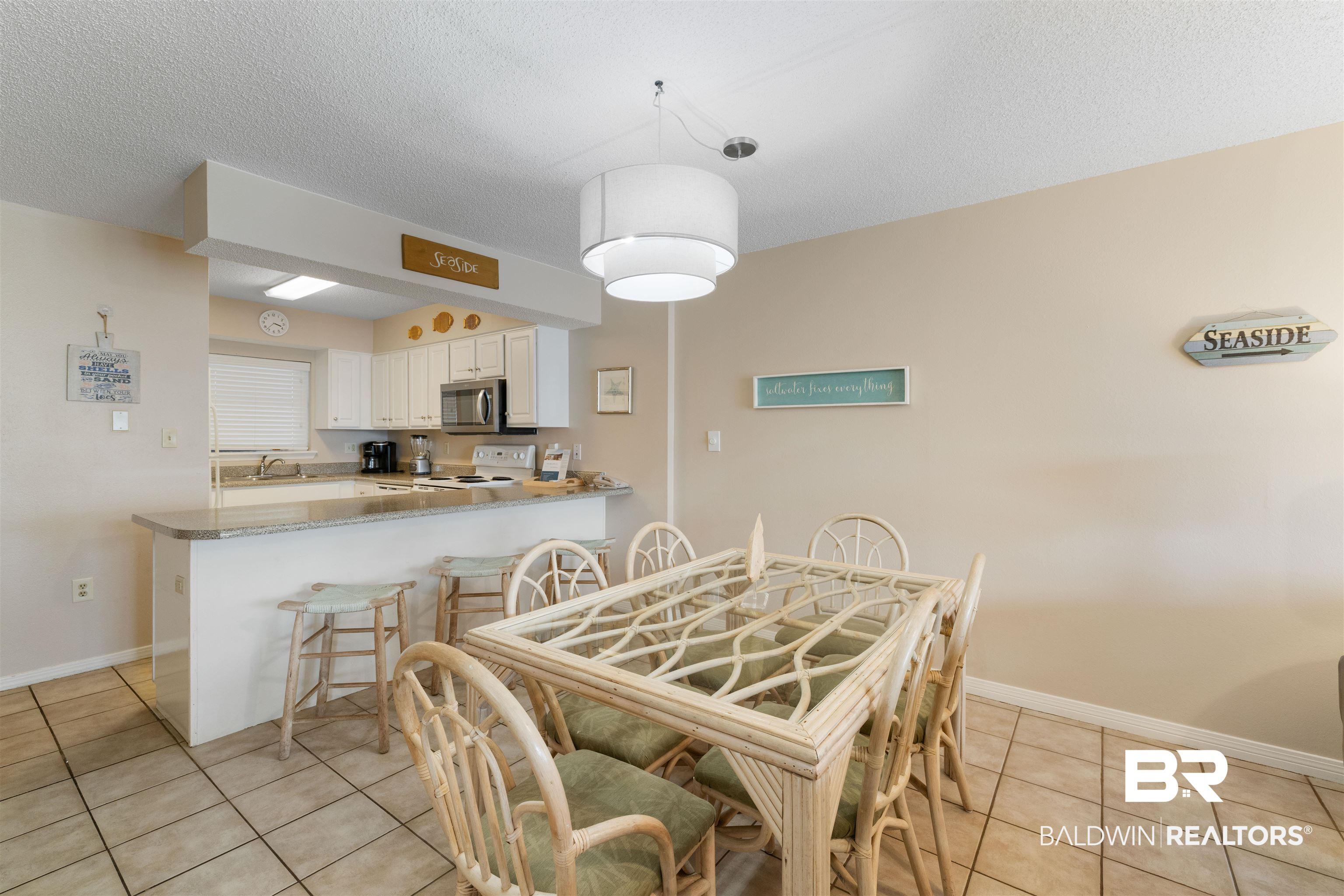 Image 3: Dining room with light tile patterned flooring and a textured ceiling