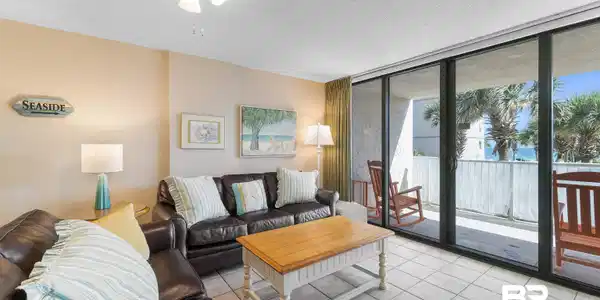 Image 4: Tiled living room with floor to ceiling windows and a textured ceiling
