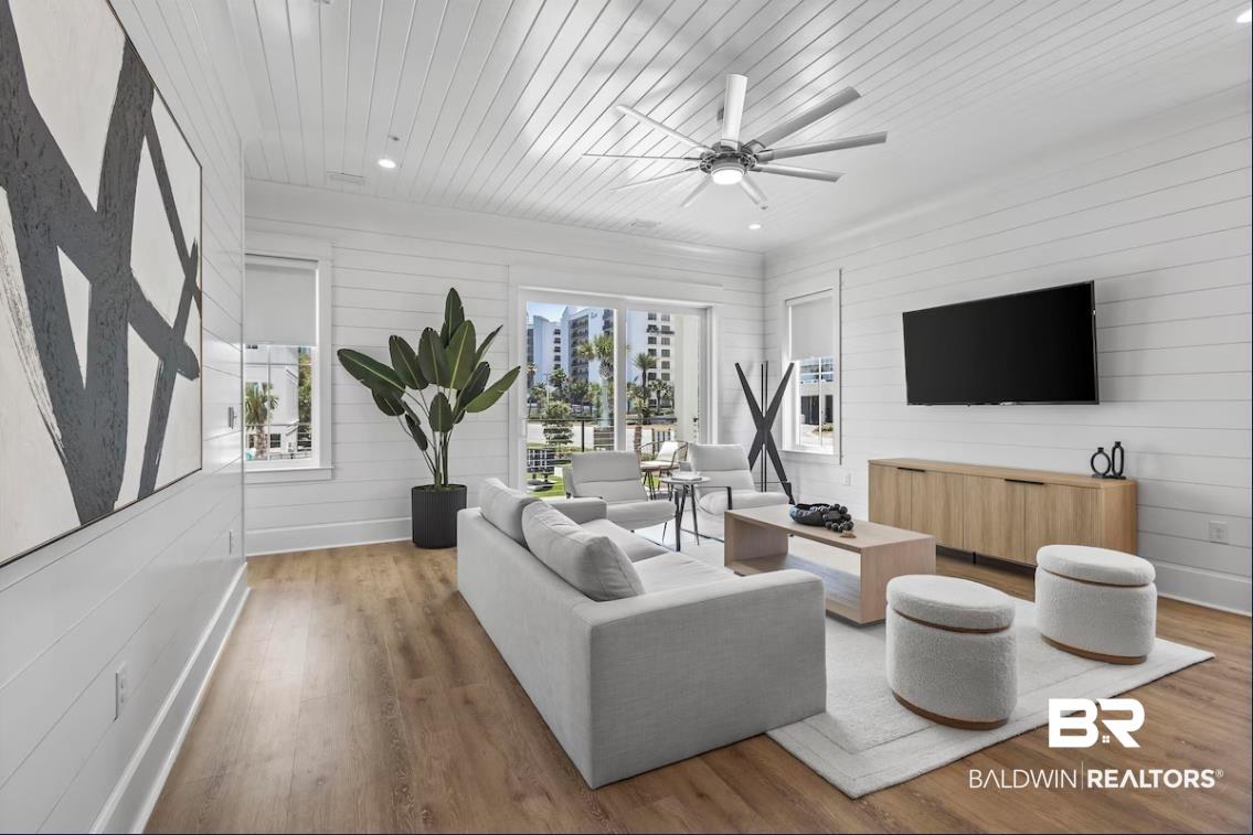 Image 3: Living room with wooden walls, wood ceiling, ceiling fan, wood finished floors, and recessed lighting