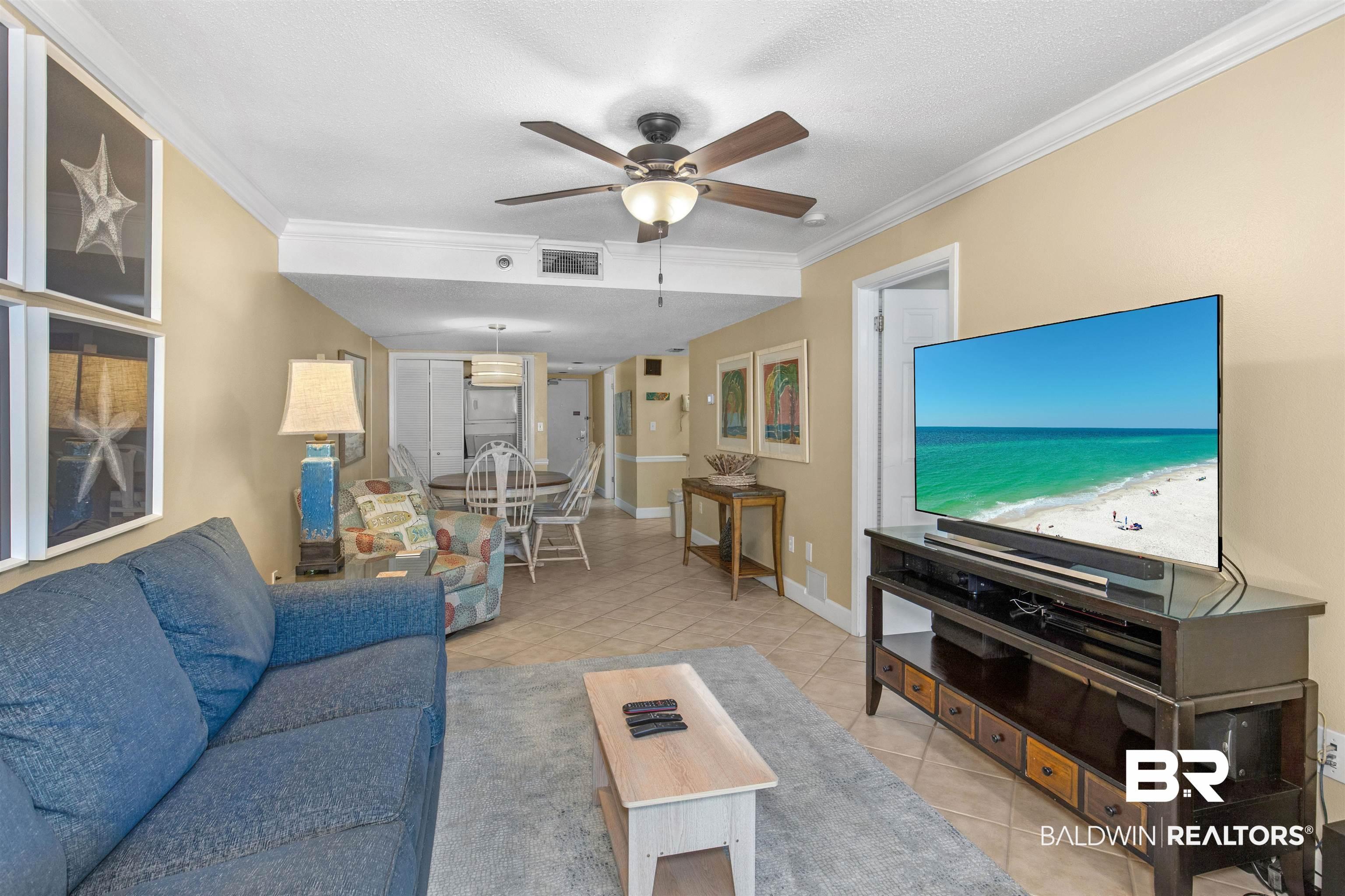 Image 4: Tiled living room featuring visible vents, ornamental molding, baseboards, and ceiling fan