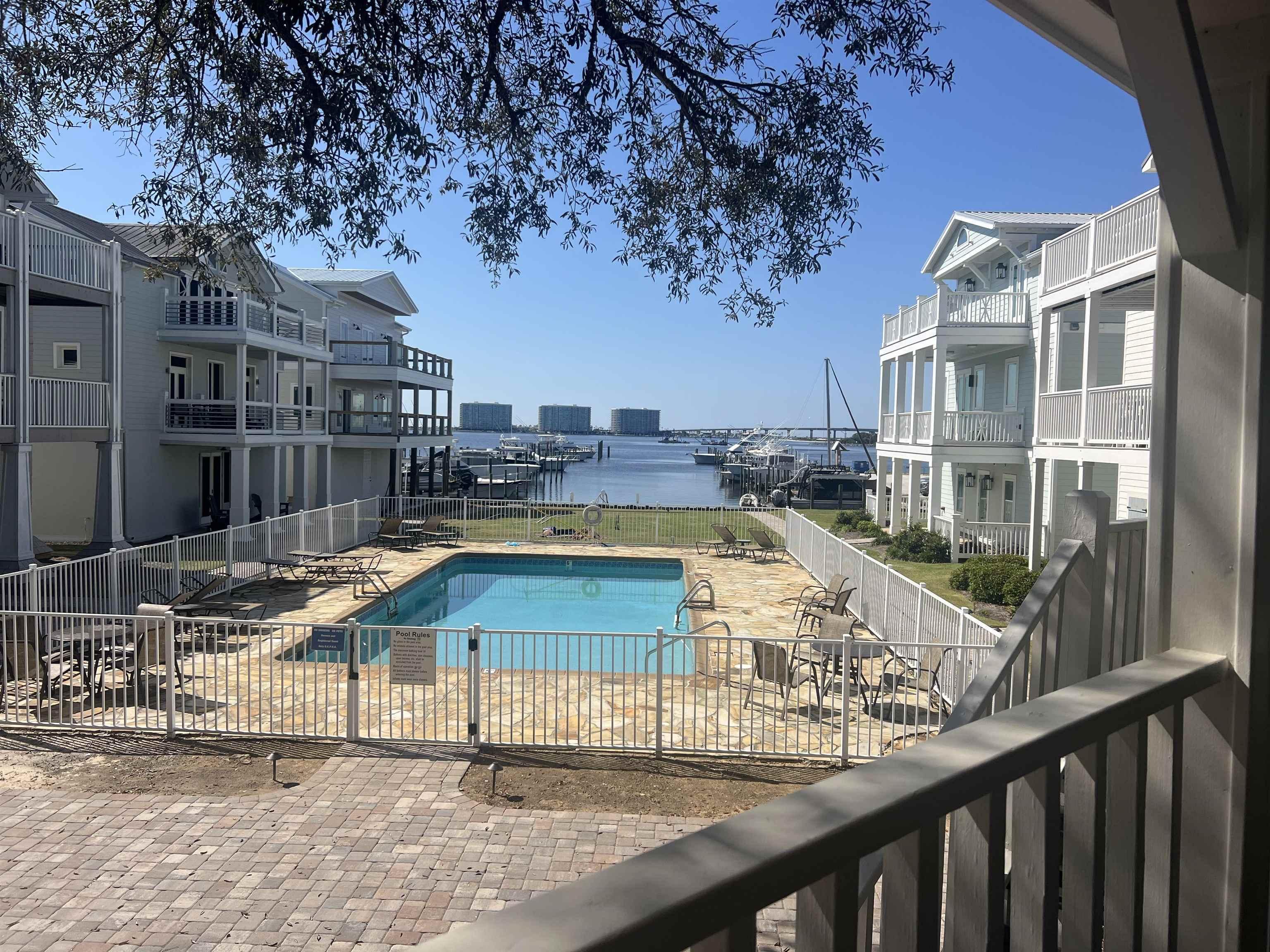 Image 4: Community pool featuring a patio, fence, and a water view