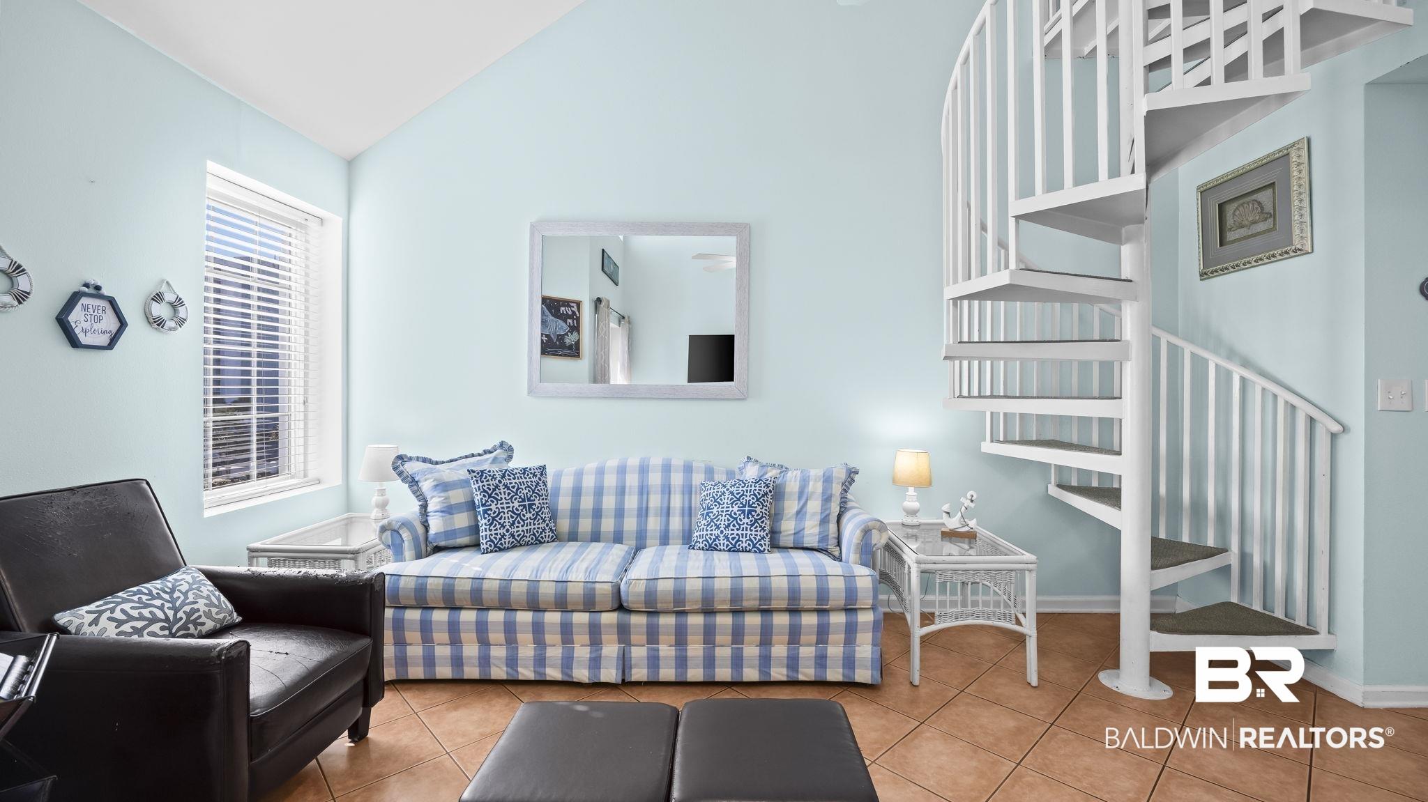 Image 2: Living room featuring vaulted ceiling and tile patterned floors