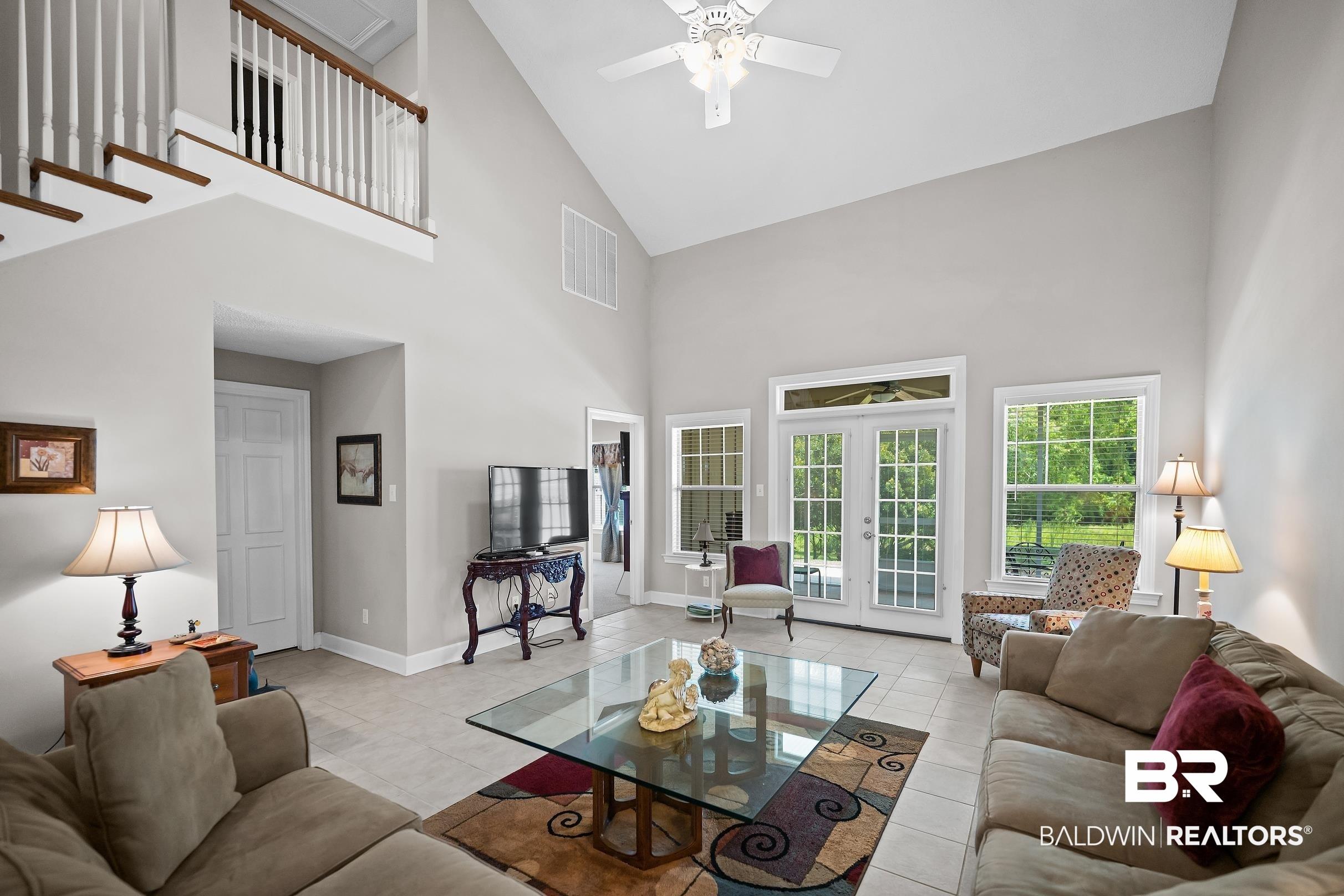 Image 2: Spacious living area featuring a vaulted ceiling and tile flooring