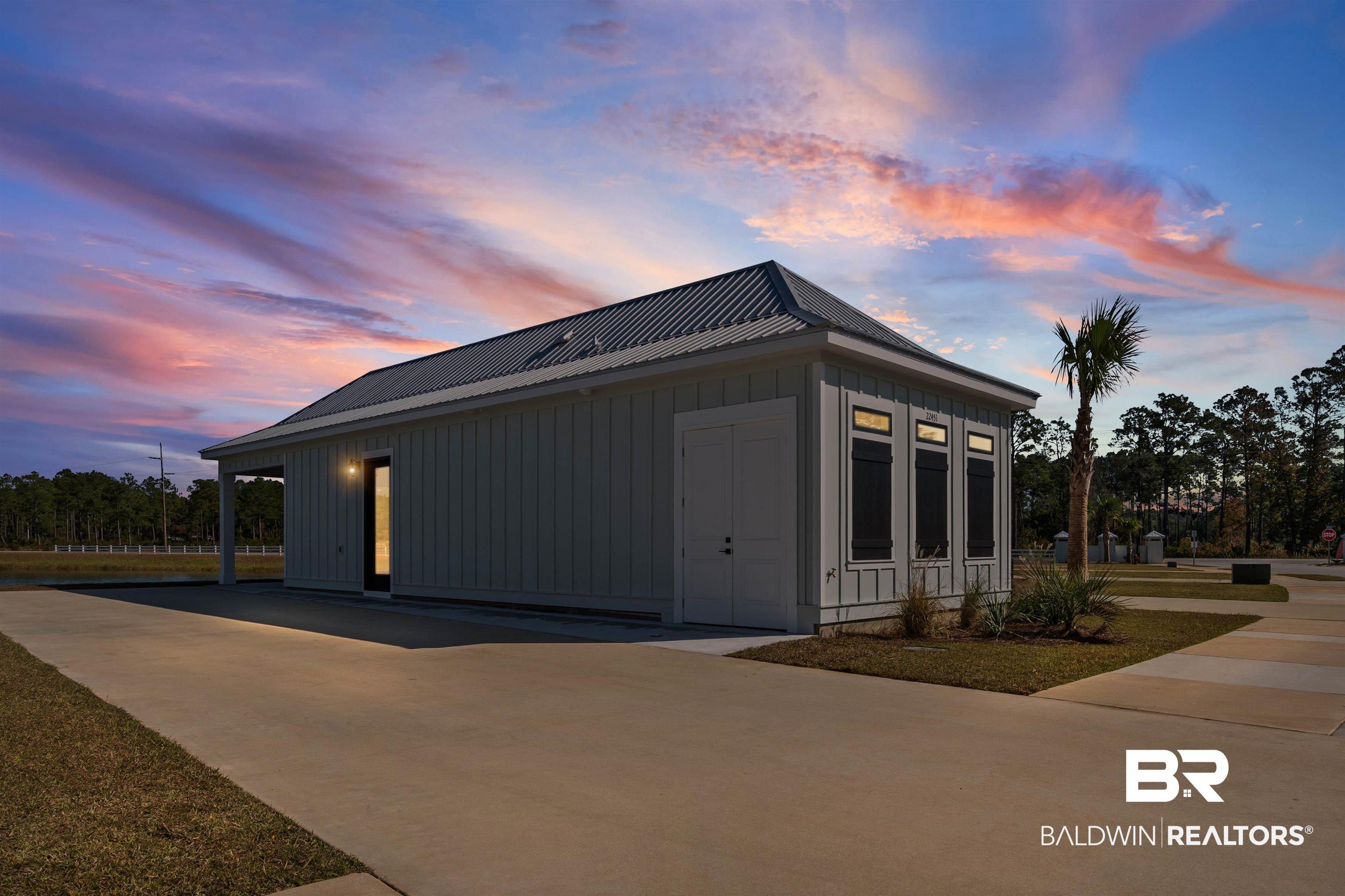 Image 1: View of side of home with board and batten siding and a metal roof