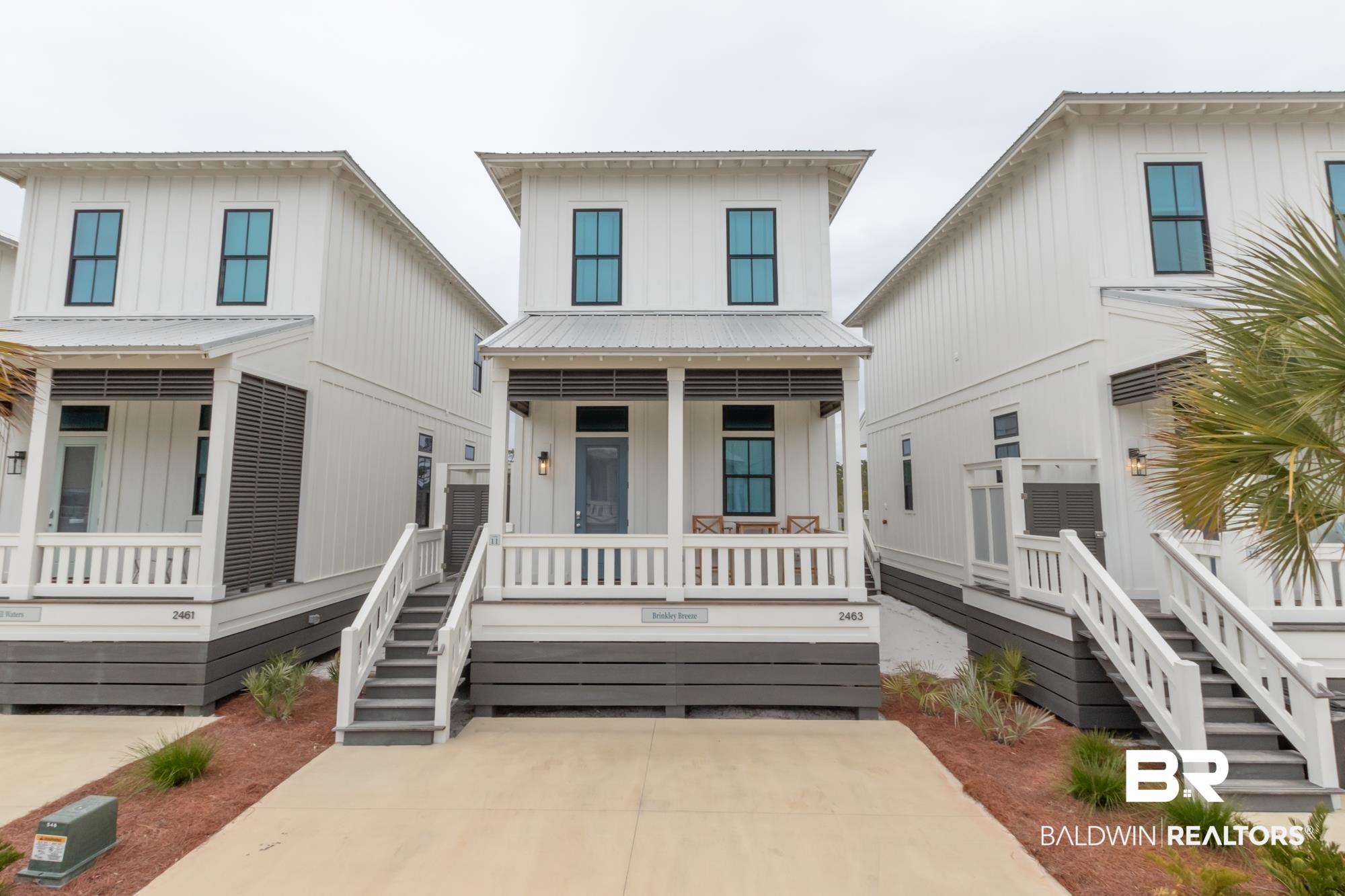 Image 2: View of front facade with covered porch, board and batten siding, and a metal roof