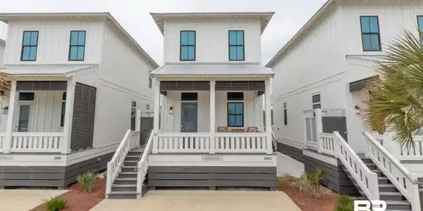 Image 2: View of front facade with covered porch, board and batten siding, and a metal roof