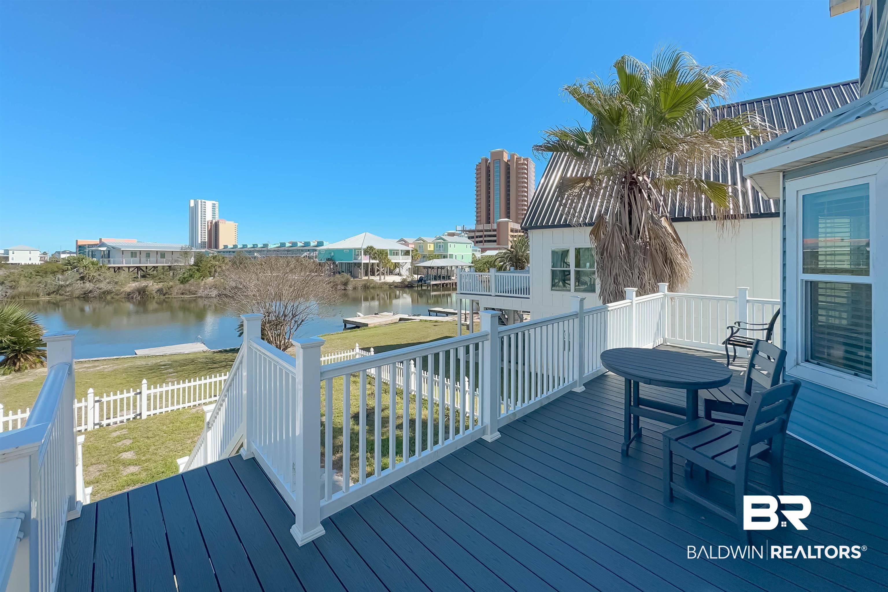 Image 3: Wooden deck featuring a water view and outdoor dining area