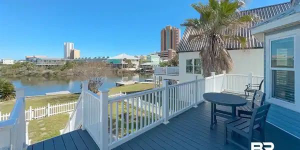 Image 3: Wooden deck featuring a water view and outdoor dining area