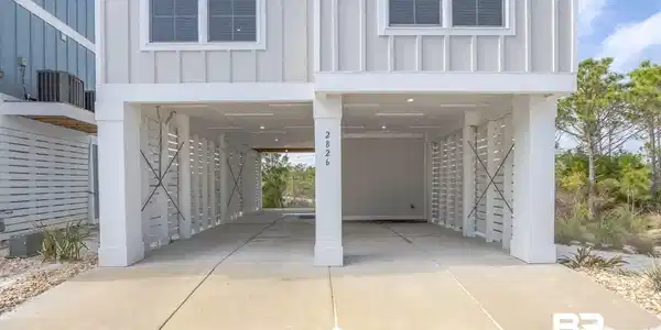 Image 3: Covered parking area with concrete driveway, recessed lighting, and vertical slat screening