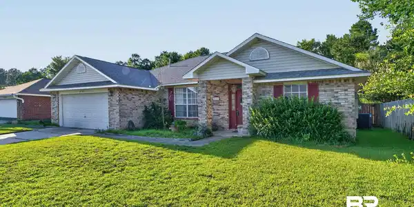Image 2: Brick exterior with light gray siding accents and an attached two-car garage