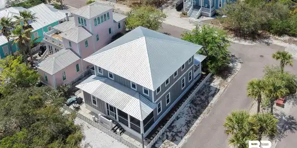Image 2: Two-story residence featuring a gray exterior with a pitched metal roof