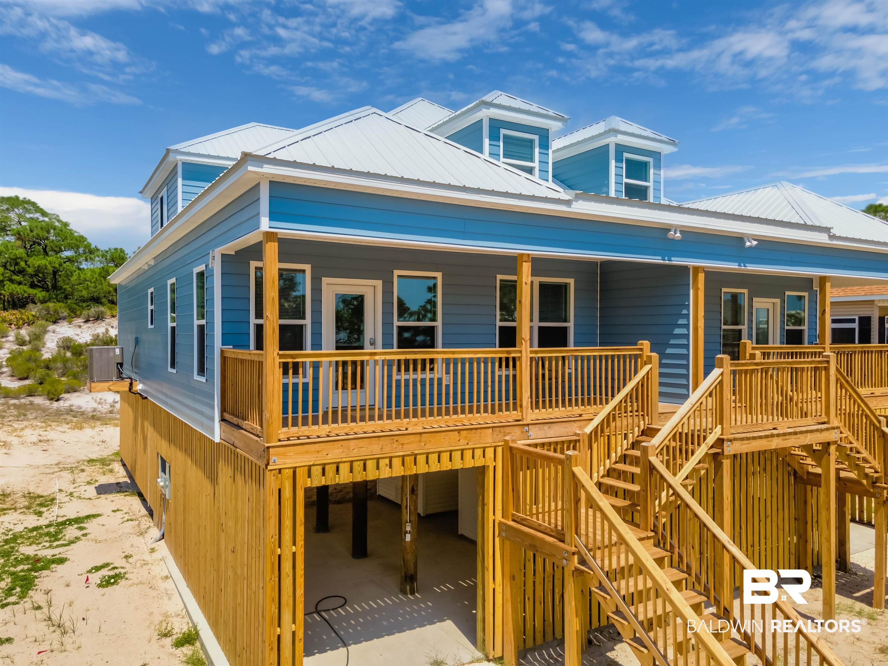 Image 2: View of front of home featuring a metal roof, covered porch, and stairs