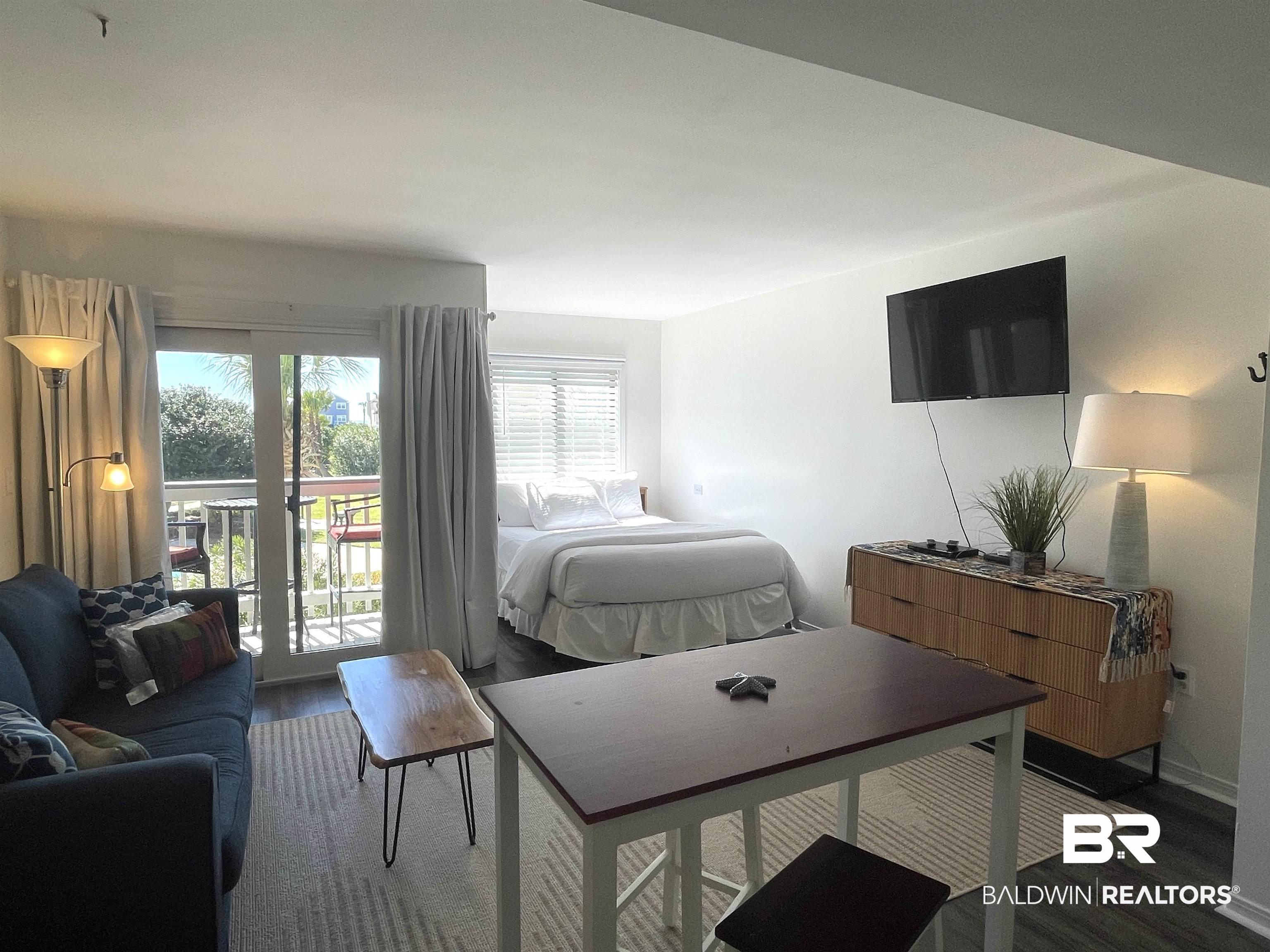Image 2: Bedroom with access to exterior and wood finished floors