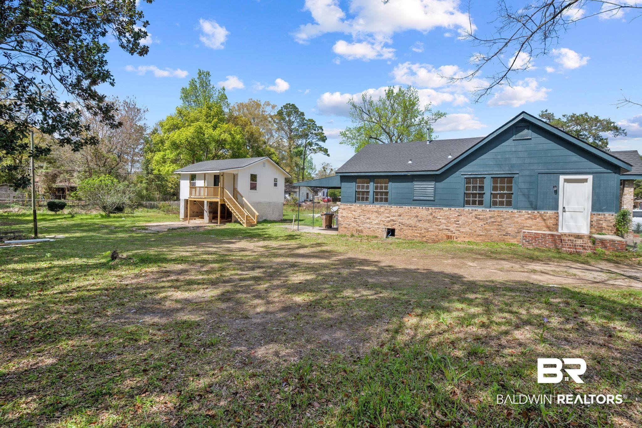 Image 1: Back of property with a yard and a patio
