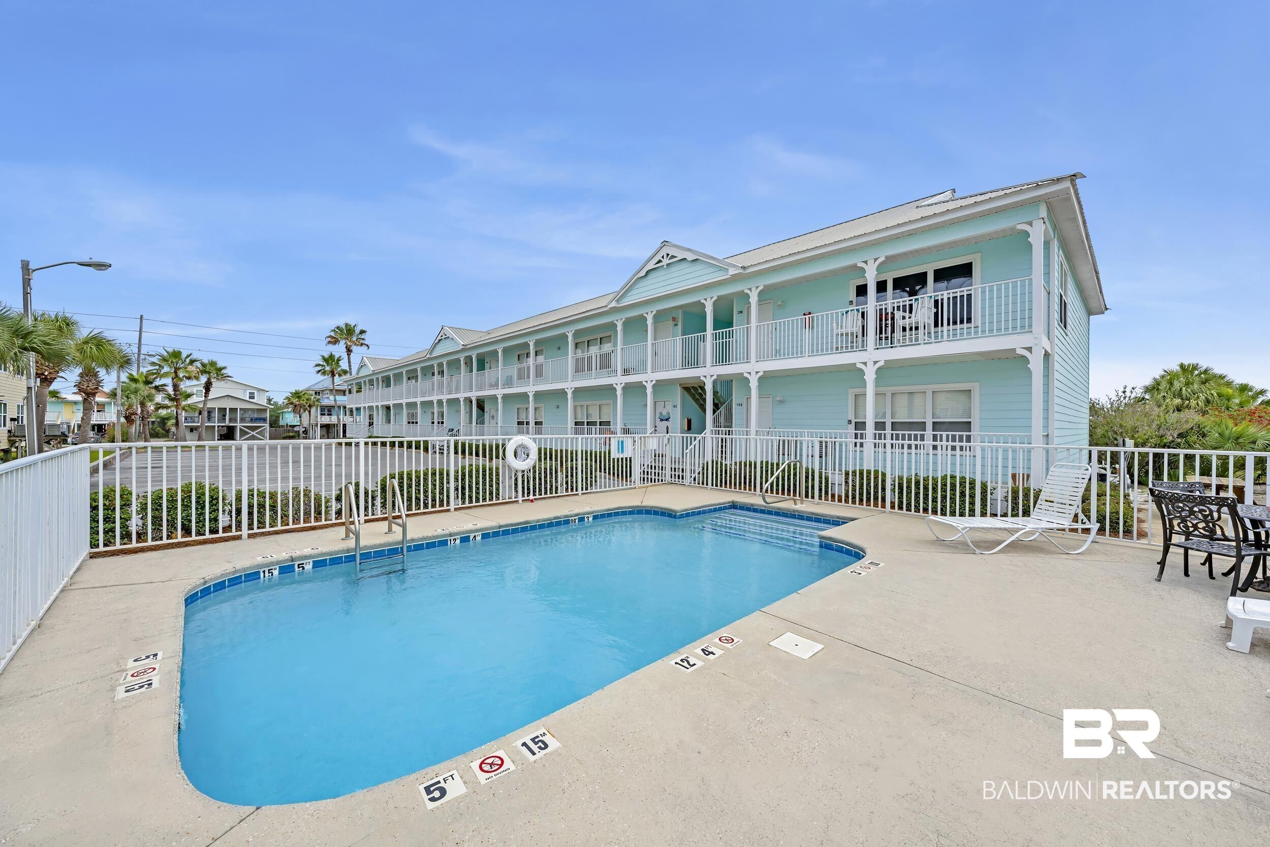 Image 2: Outdoor swimming pool featuring a concrete deck and surrounding white fencing