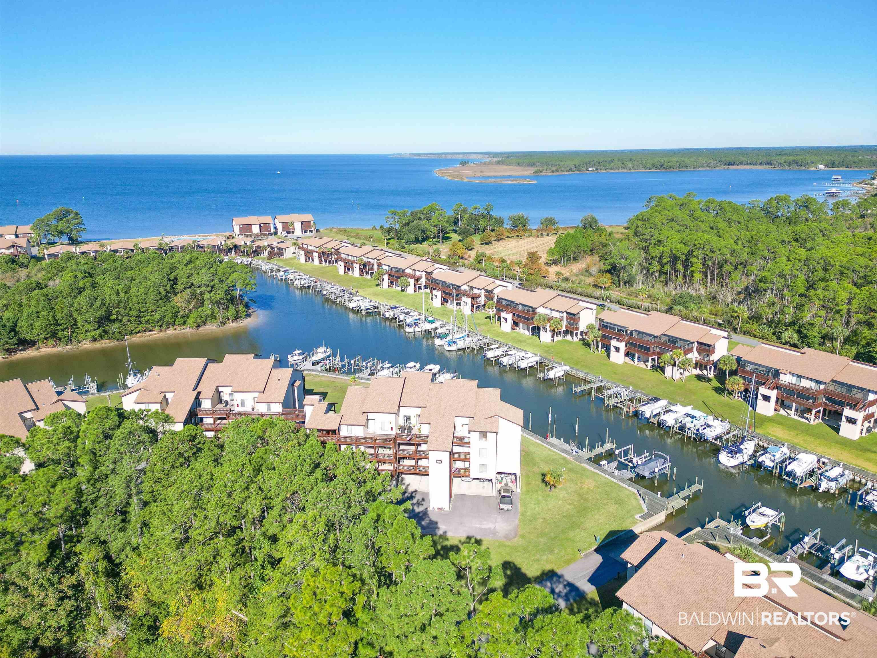 Image 1: Waterfront community featuring direct access to a private marina, individual boat slips, and multiple multi-story residential buildings with private balconies