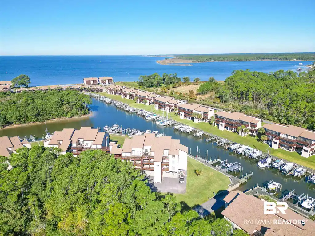 Image 1: Waterfront community featuring direct access to a private marina, individual boat slips, and multiple multi-story residential buildings with private balconies