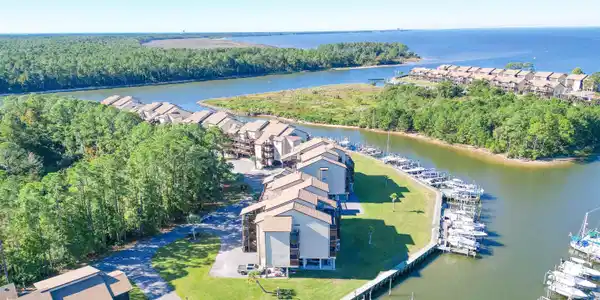 Image 3: Waterfront community featuring multiple multi-story residential buildings with private balconies, surrounded by mature trees
