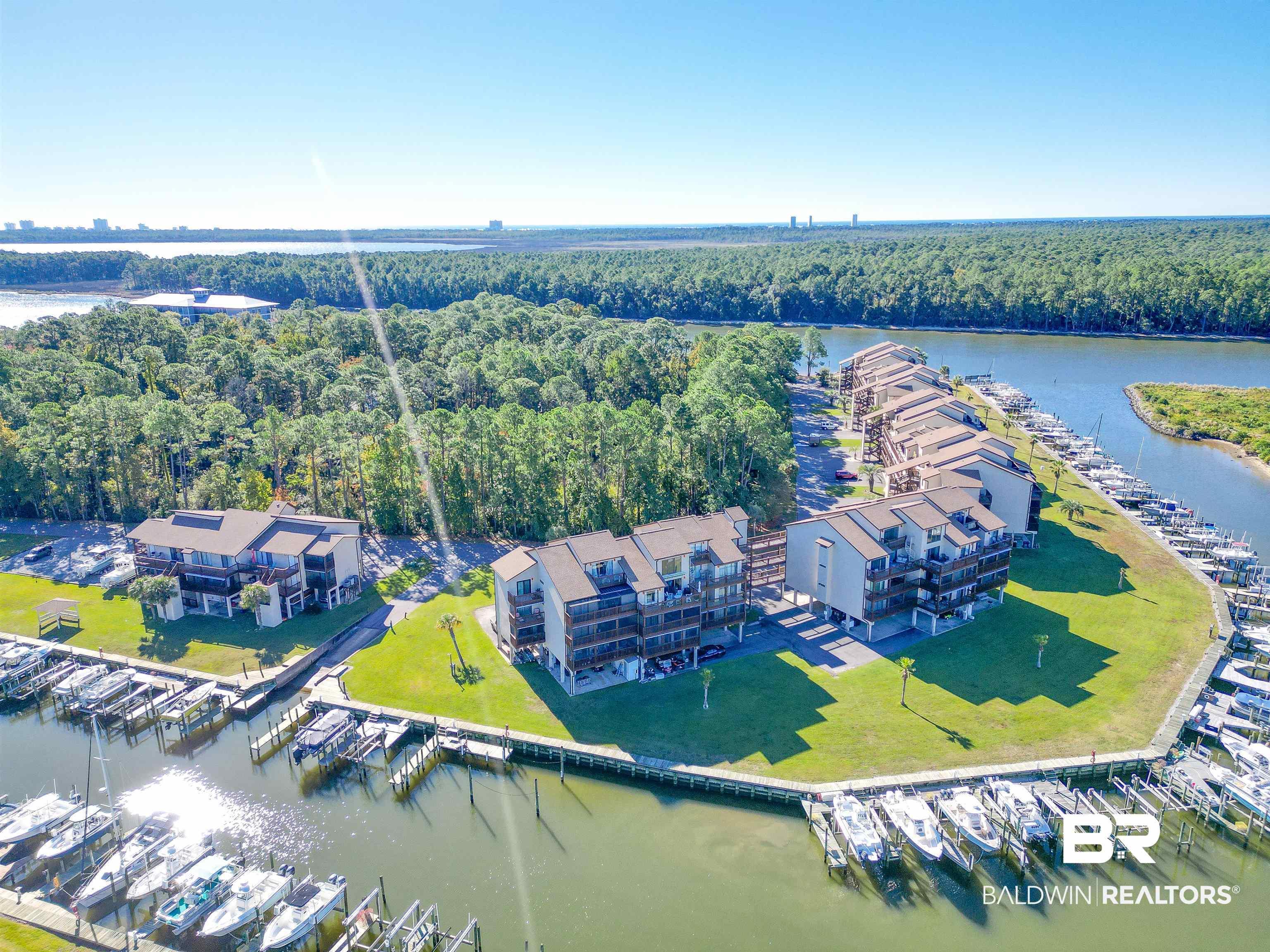 Image 4: Waterfront property with multiple residential buildings featuring private balconies, individual boat slips, and a manicured green space