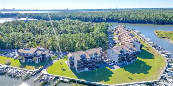 Image 4: Waterfront property with multiple residential buildings featuring private balconies, individual boat slips, and a manicured green space