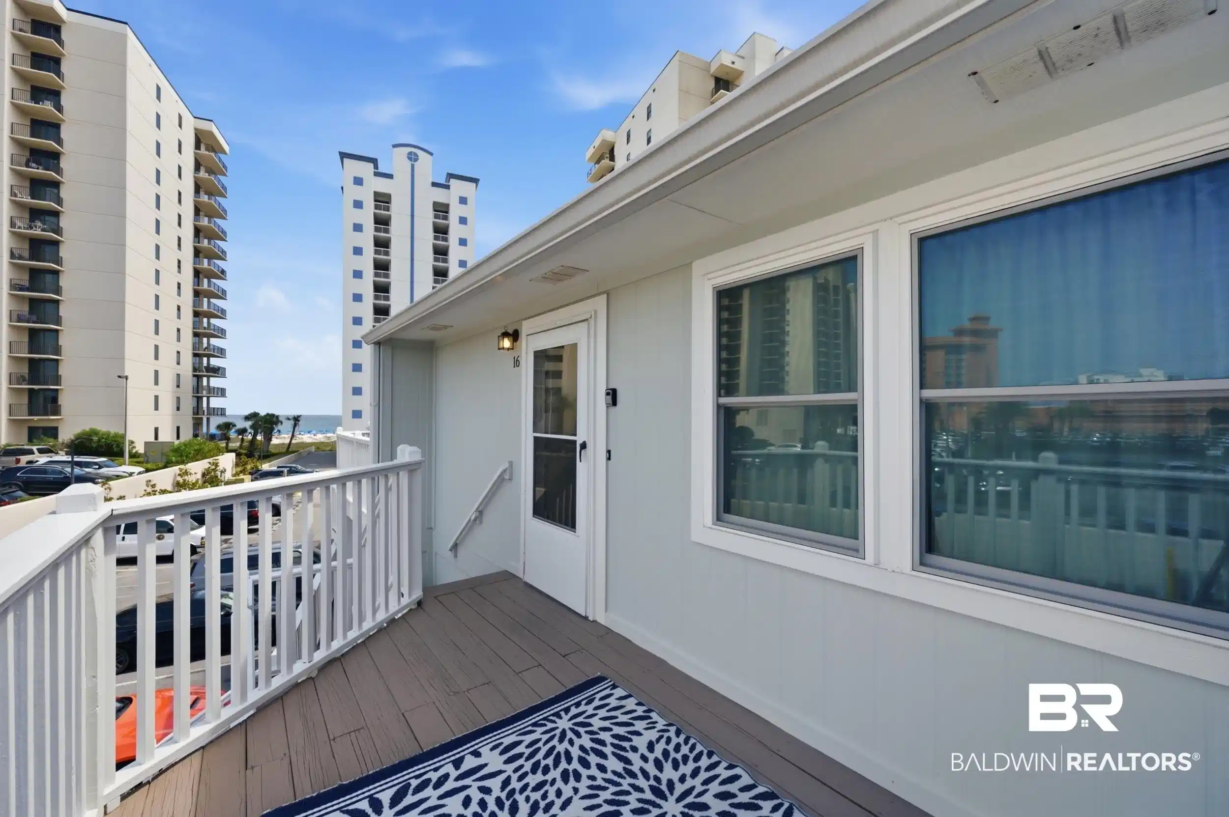 Image 1: Outdoor deck featuring wood-finish decking and white painted railings