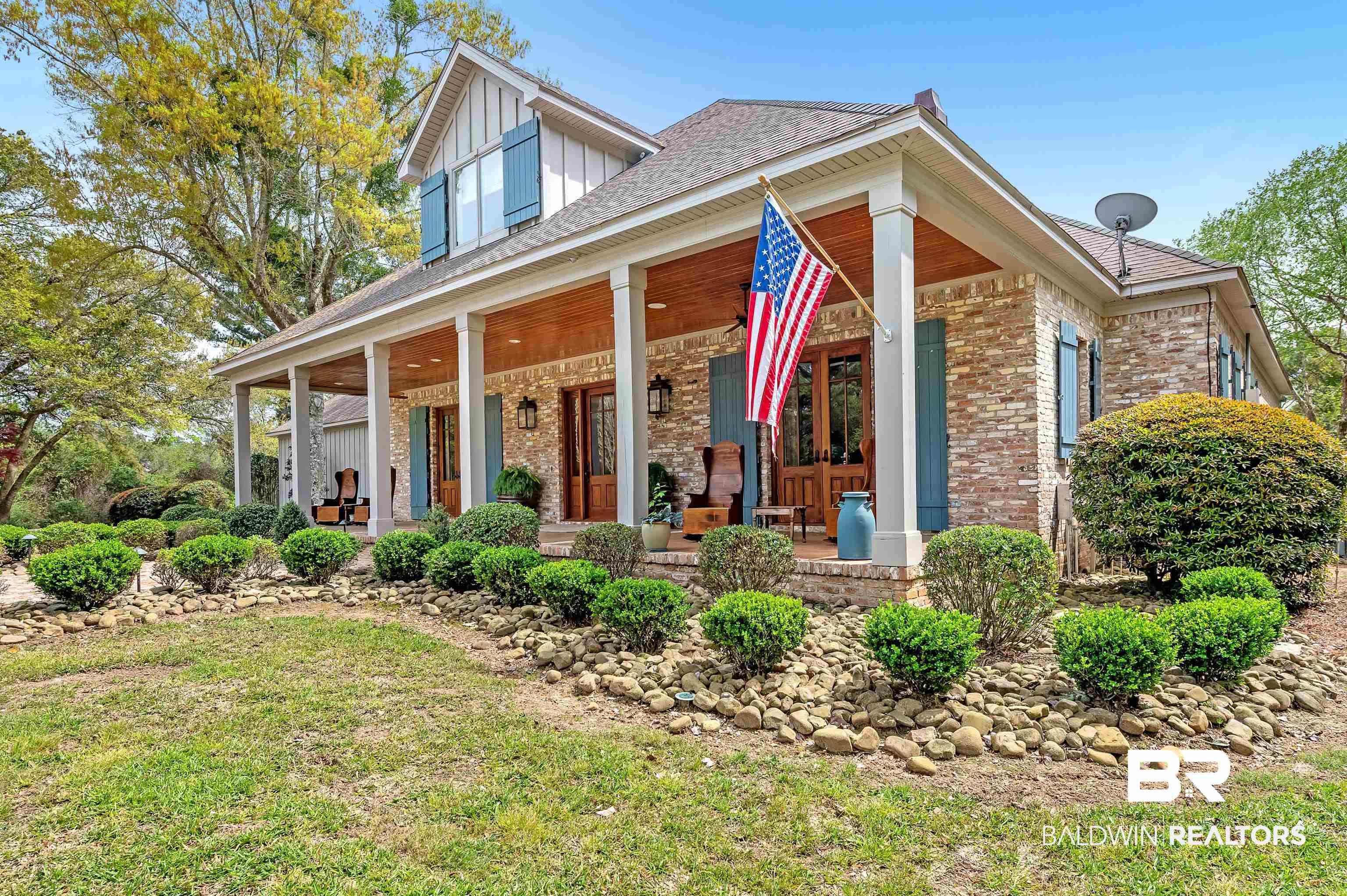 Image 3: View of front of property with a front yard, covered porch, and brick siding