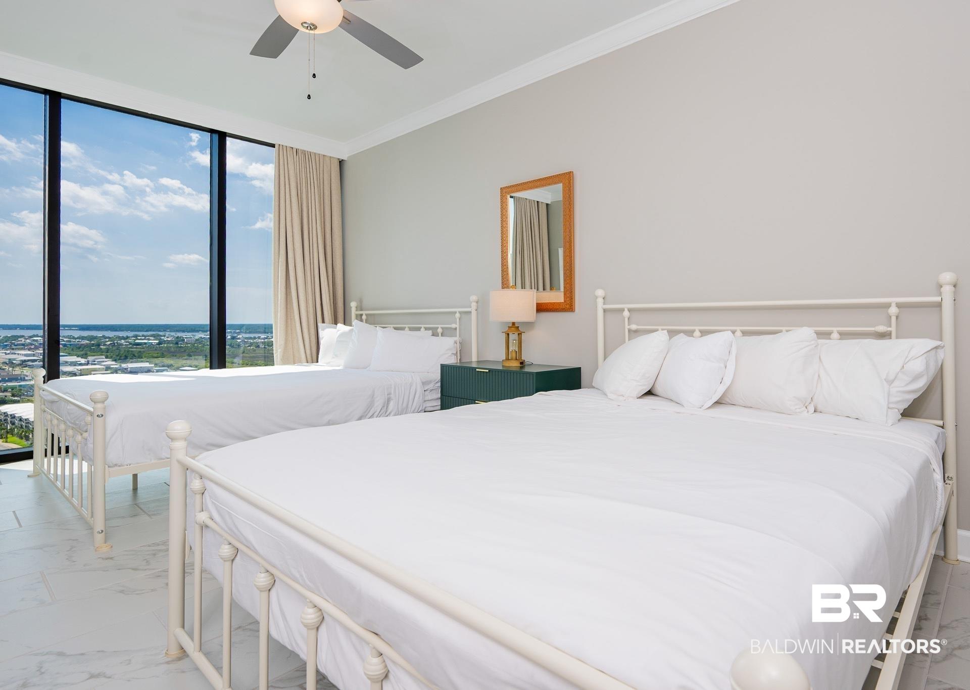 Image 4: Bedroom featuring light marble finish floors, a wall of windows, ceiling fan, and crown molding