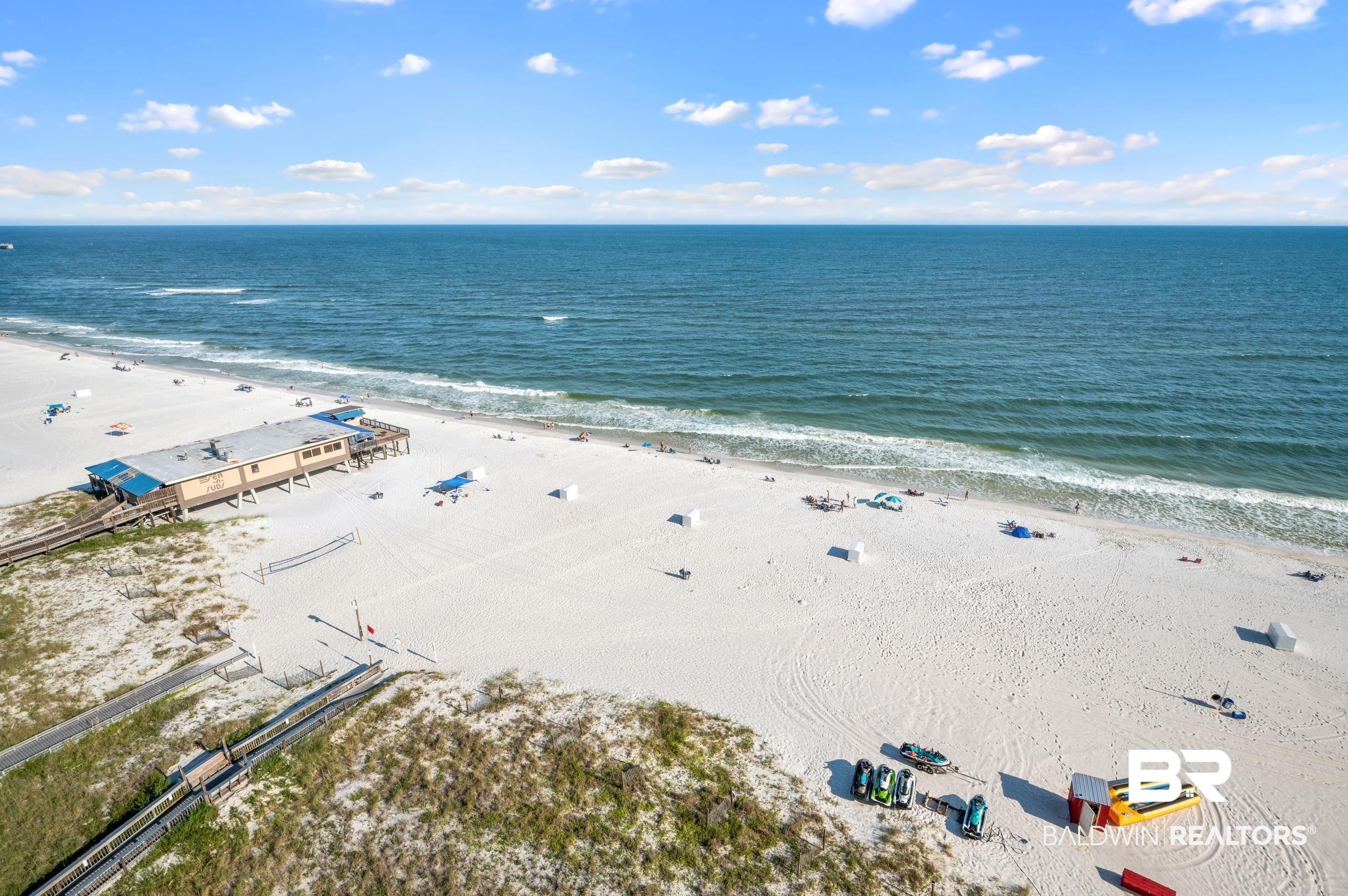 Image 2: Expansive beachfront with white sand and clear blue water