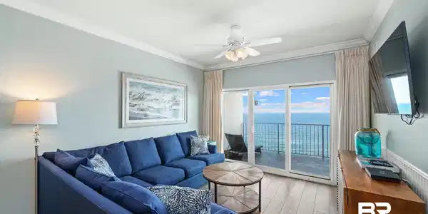 Image 3: Sliding glass doors opening to a balcony with water views, wood-finish flooring, crown molding, and a ceiling fan