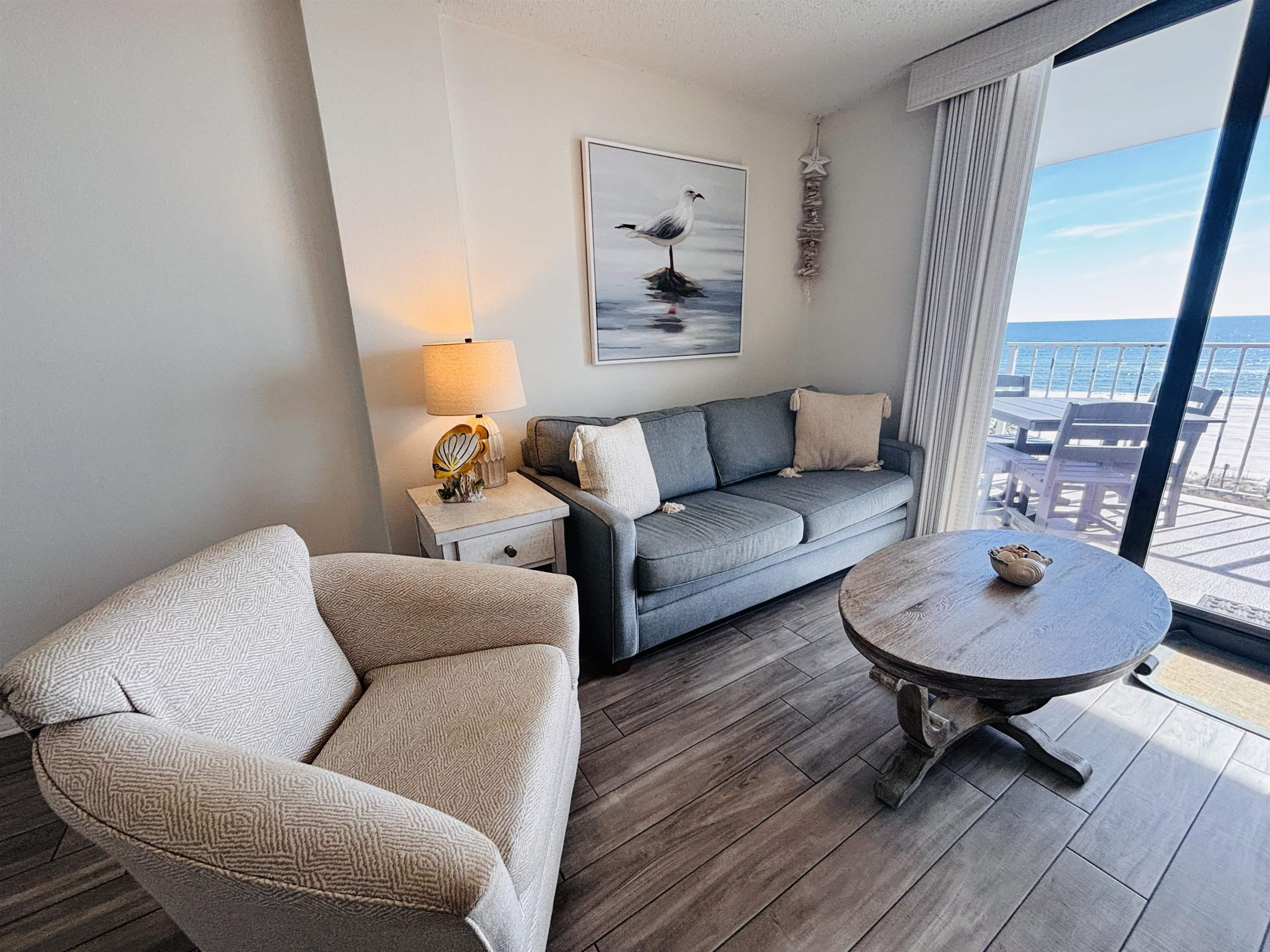 Image 3: Living room with wood finish floors, a water view, and a textured ceiling