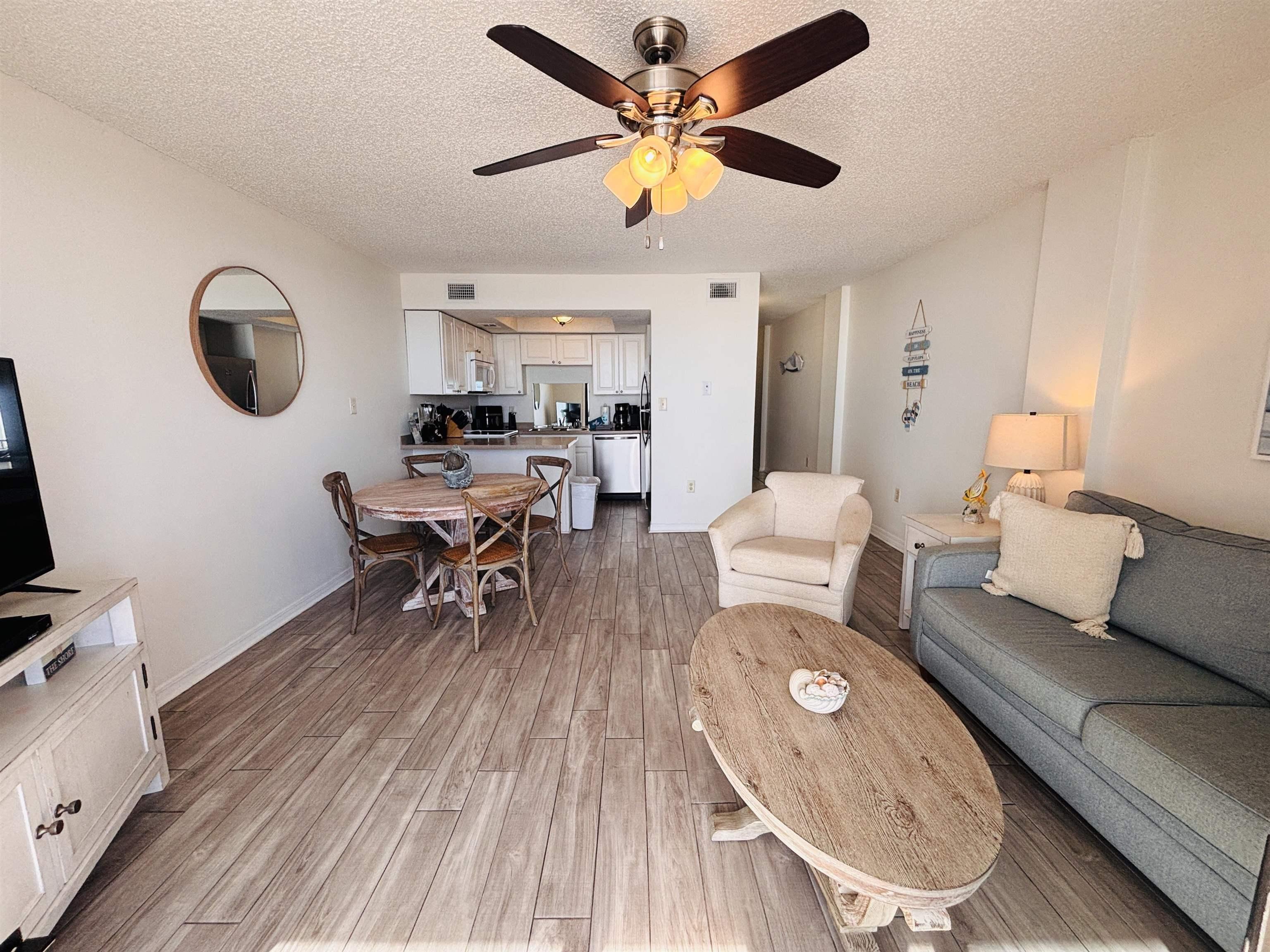 Image 4: Living area with a textured ceiling, light wood finished floors, and ceiling fan