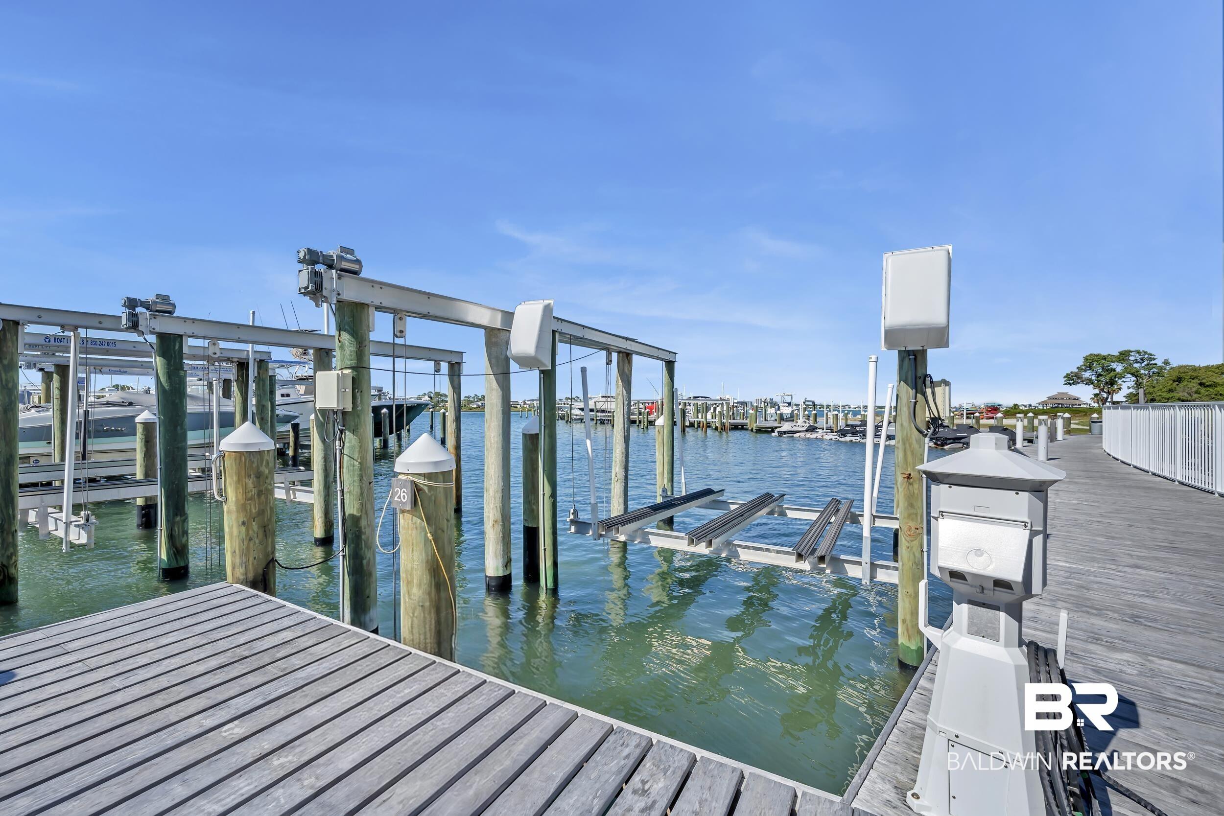 Image 2: Dock featuring multiple boat lifts and direct water access, complemented by a composite decking walkway