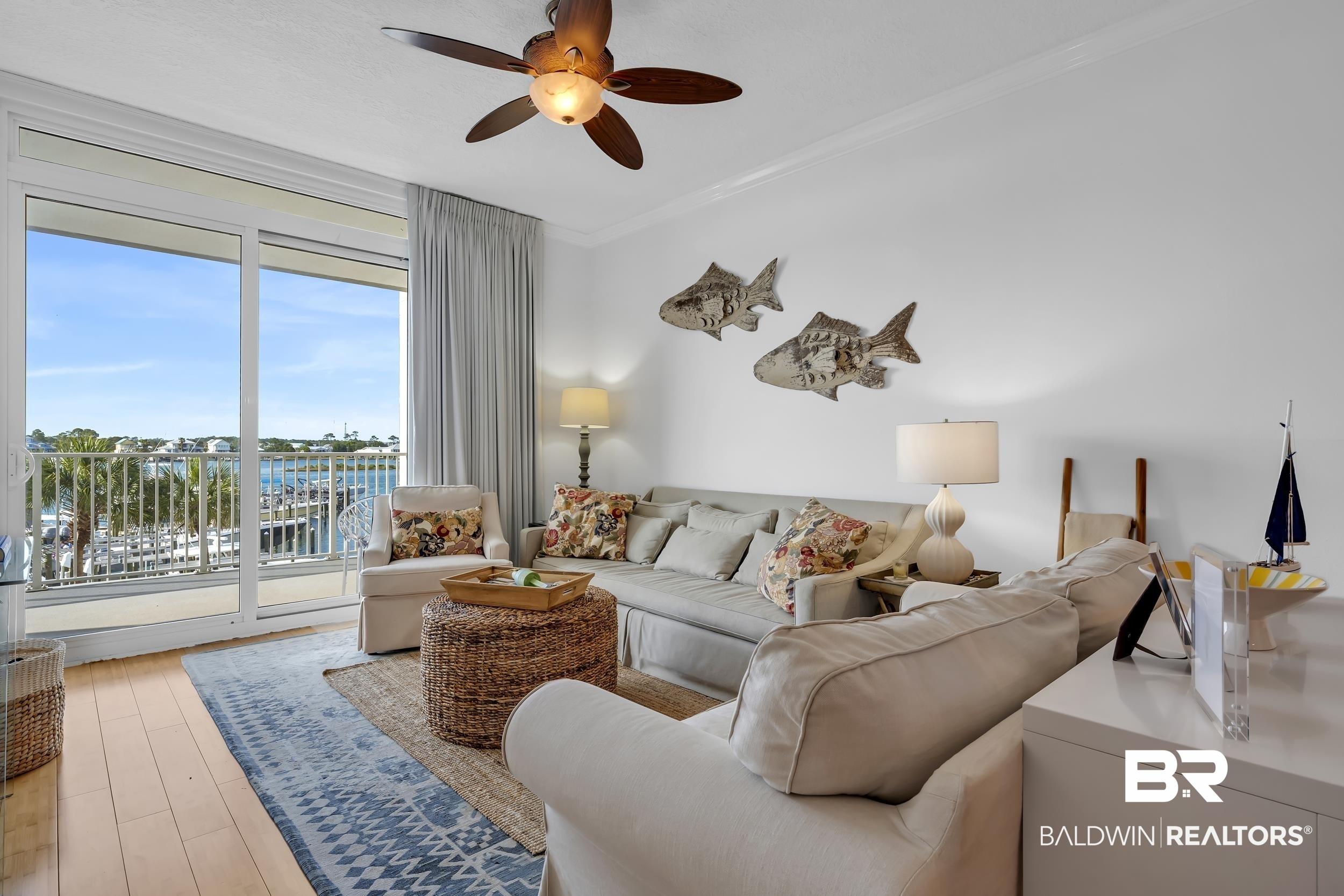 Image 3: Bright living area featuring wood-finish flooring and a ceiling fan