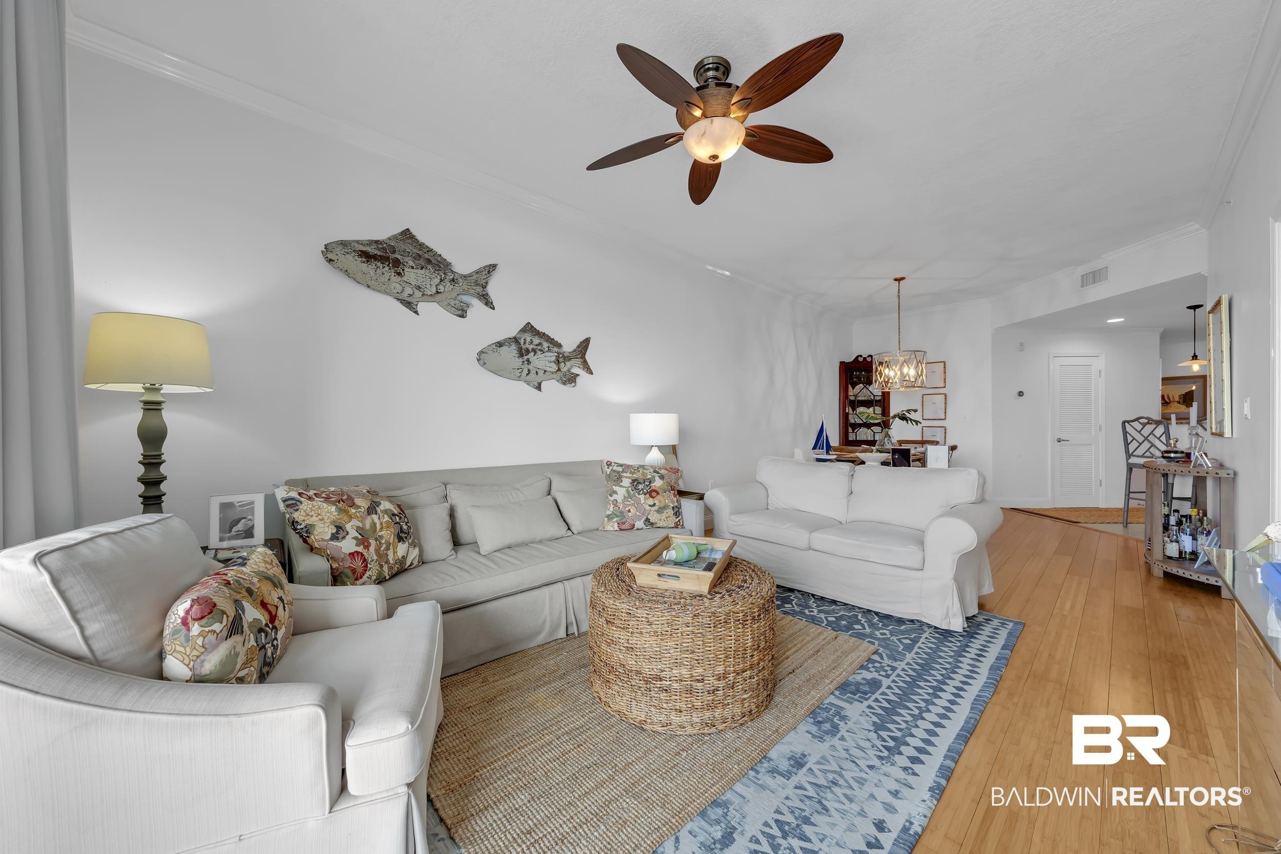 Image 4: Open-concept living area featuring a decorative ceiling fan, crown molding, light wood-finish flooring, and recessed lighting